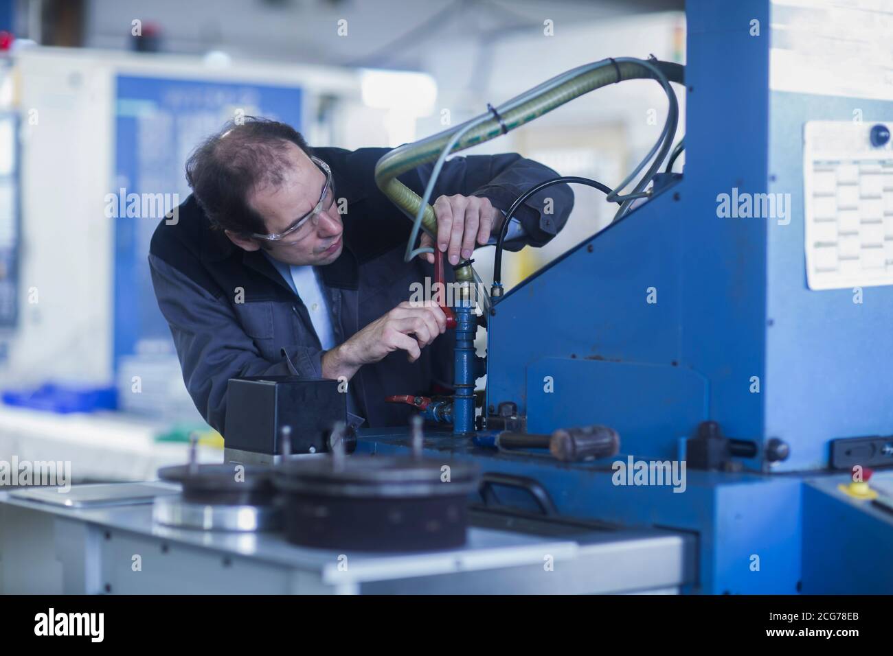 Engineer checking equipment at an industrial plant, Germany Stock Photo