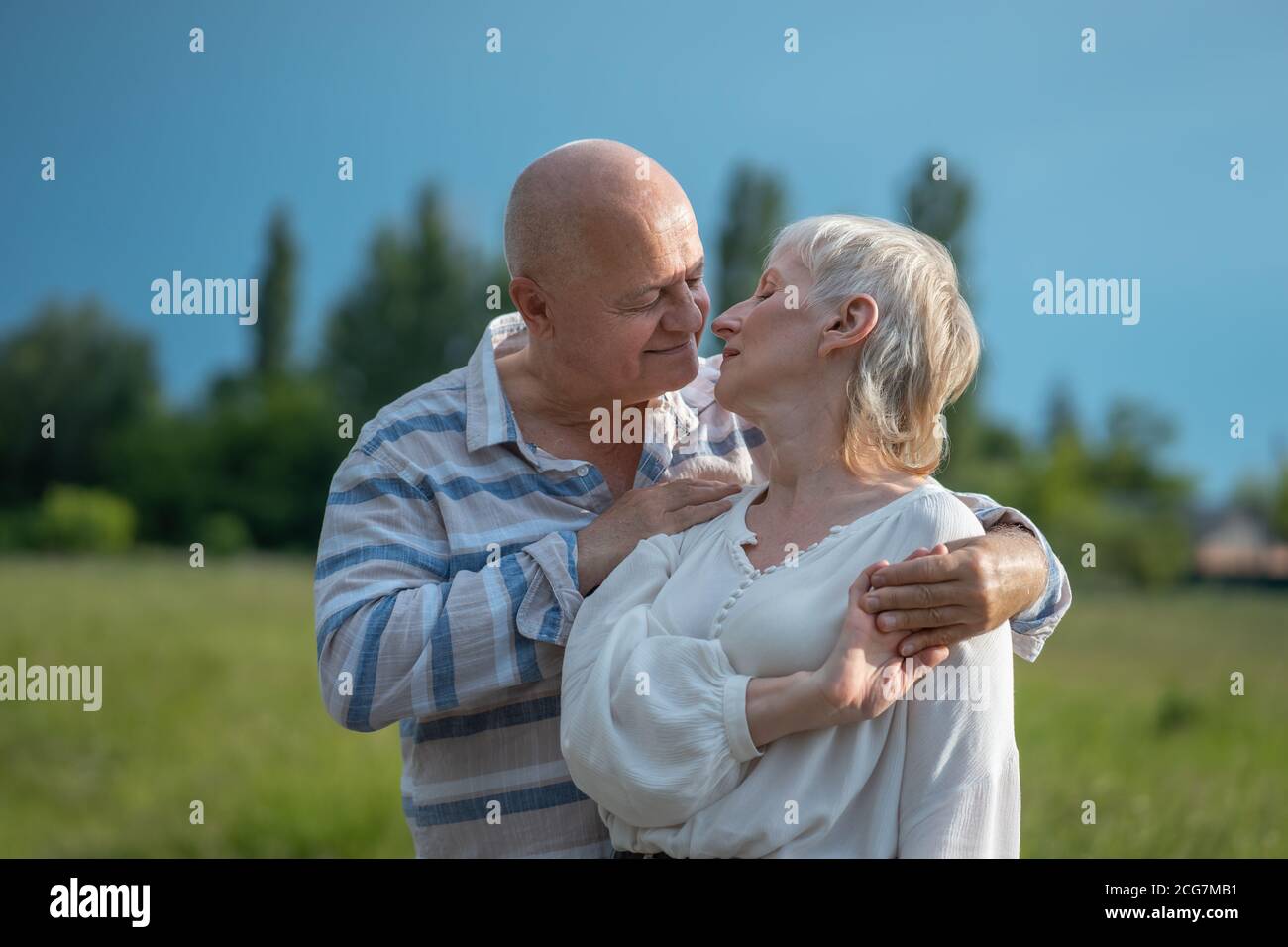 happy senior couple dating, hugging and kissing outdoor at sunset Stock Photo