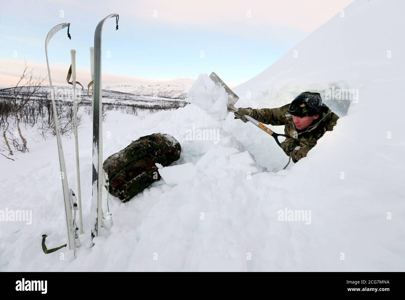 A marine from Edinburgh digs a snow hole to camp in, as troops take part in Exercise Hairspring 2013, which focuses on cold weather survival and warfare training for Royal Marines Commando Reservists in the mountains range near to Porsanger Garrison near Lakselv, Norway. Stock Photo