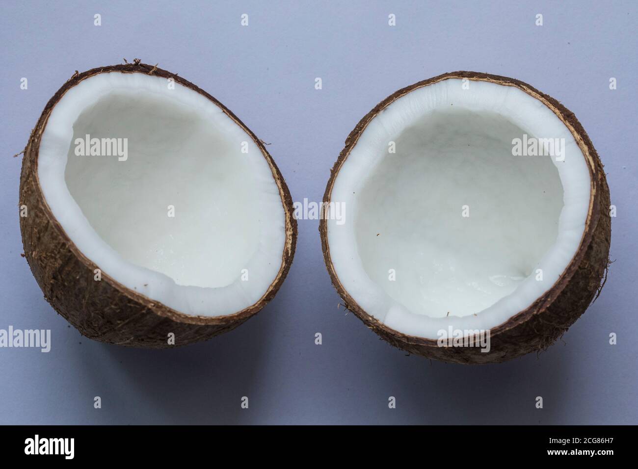 Two halves of a coconut on white background. Stock Photo
