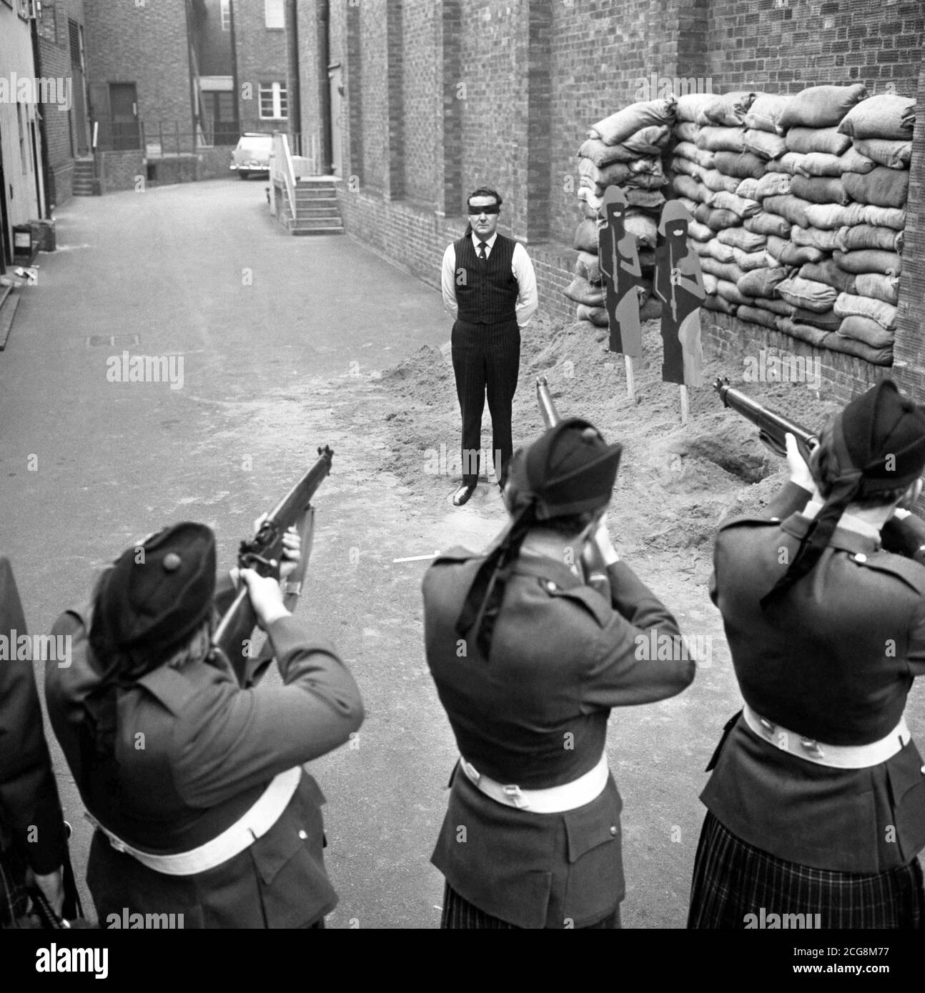 John Steed, played by Patrick Macnee, faces a firing squad in 'Esprit de Corps', the penultimate episode of the third Avengers series. Stock Photo