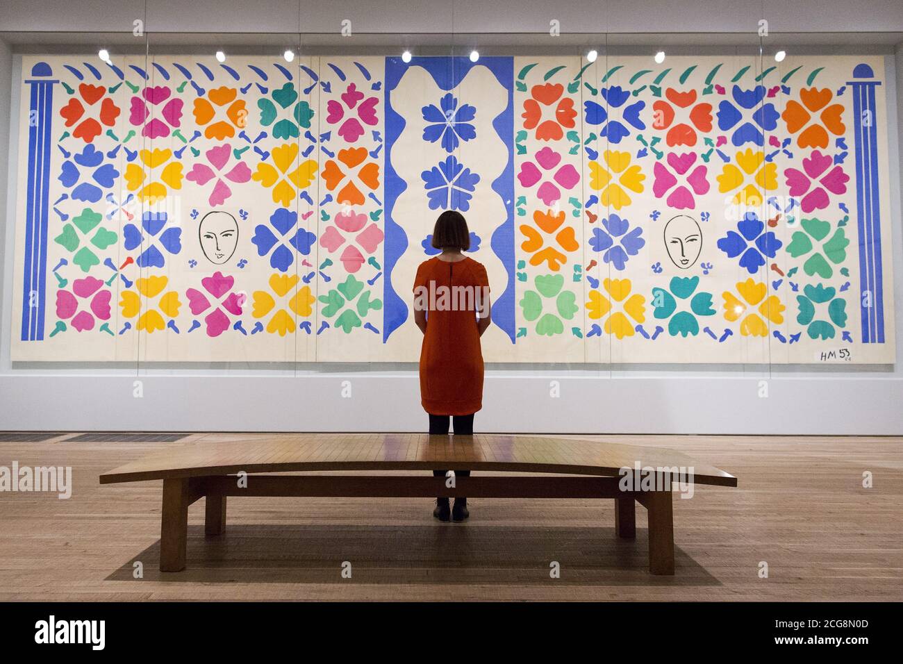 A gallery assistant poses in front of &quot;Large Composition with Masks  1953&quot; by Henri Matisse at The Cut-Outs exhibition at the Tate Modern,  London Stock Photo - Alamy