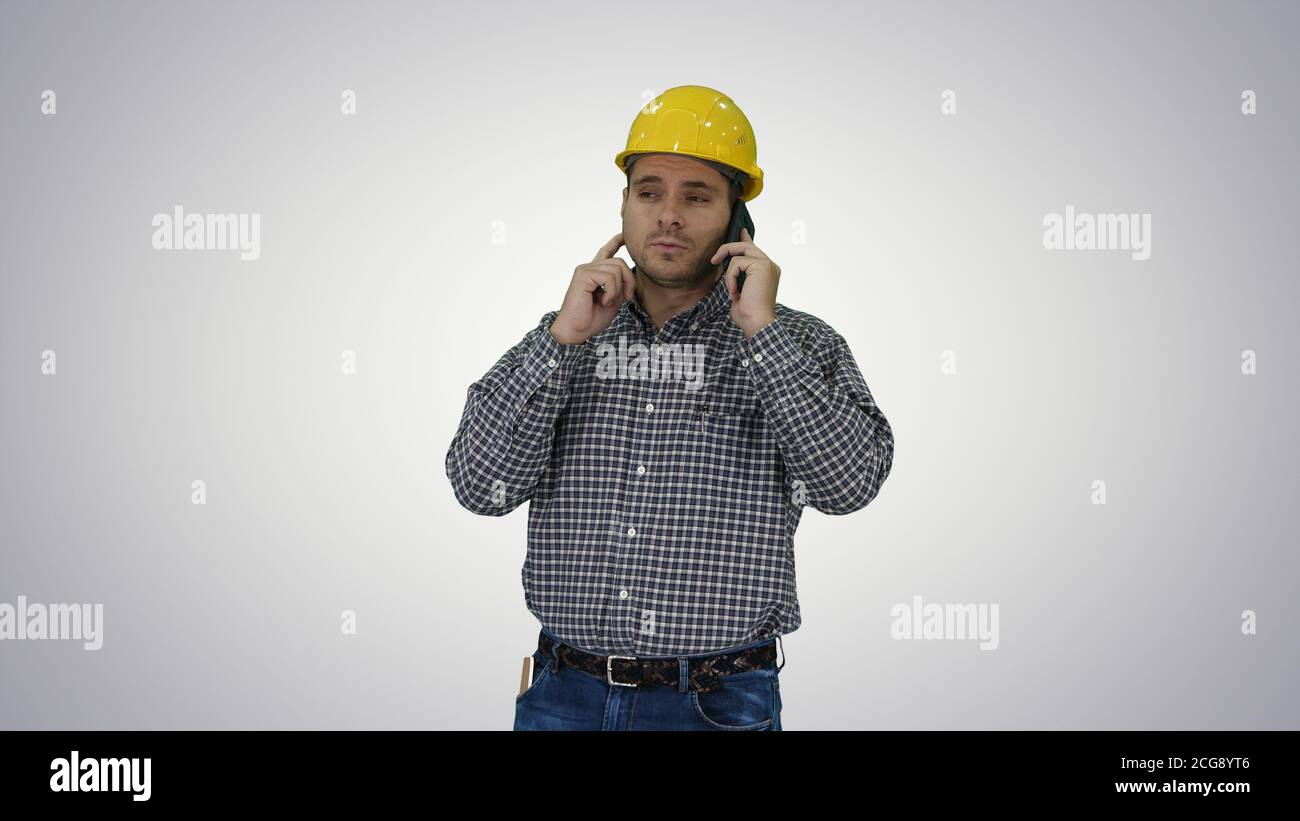 Construction worker using smartphone on gradient background. Stock Photo