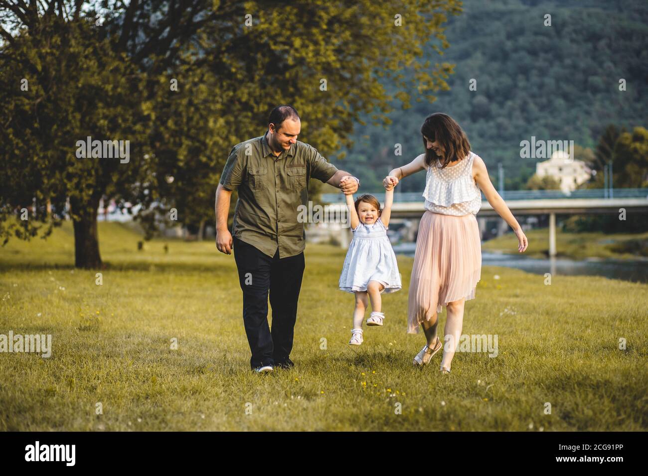 Happy family, mother, father and little daughter have fun outdoors. Stock Photo
