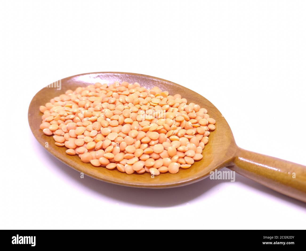 Red Lentils or Masoor Dal in a spoon isolated on White Background. Red