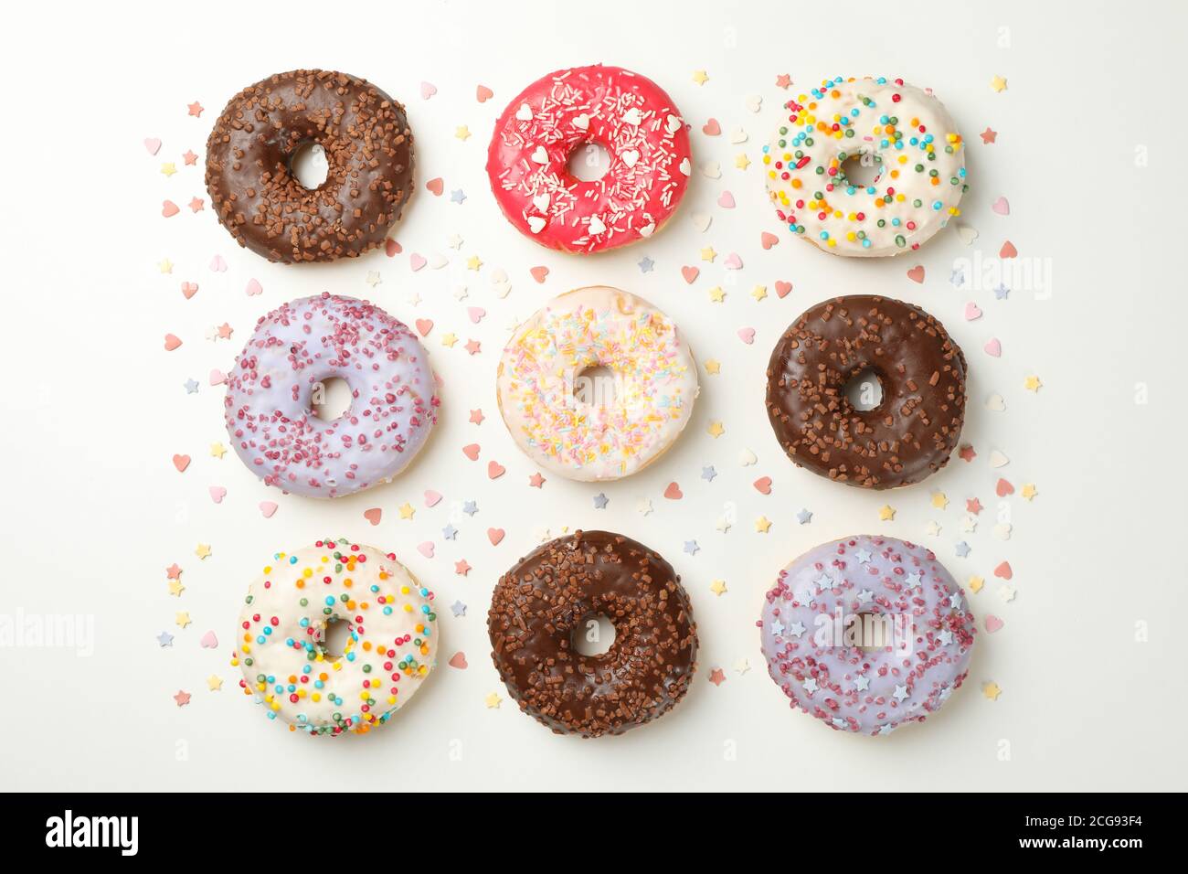 Flat lay with tasty donuts on white background Stock Photo - Alamy