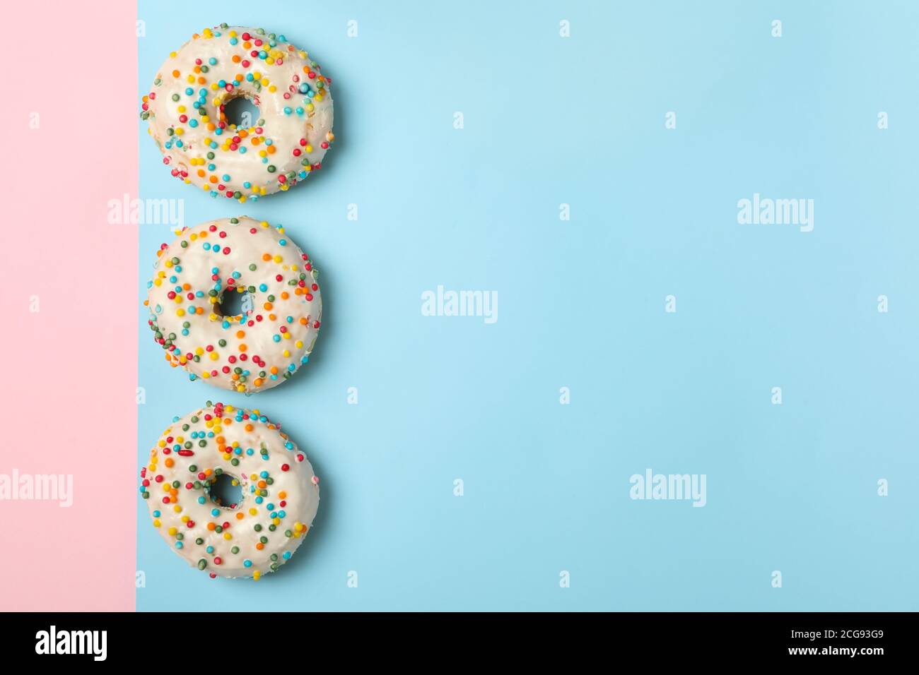 Tasty donuts on two tone background, top view Stock Photo