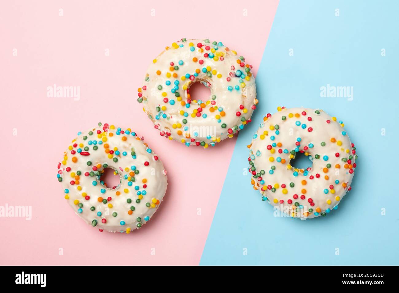 Tasty donuts on two tone background, top view Stock Photo