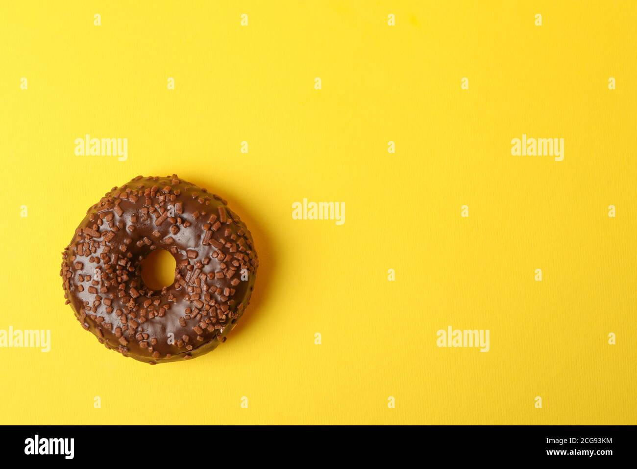 Tasty chocolate donut on yellow background, space for text Stock Photo ...
