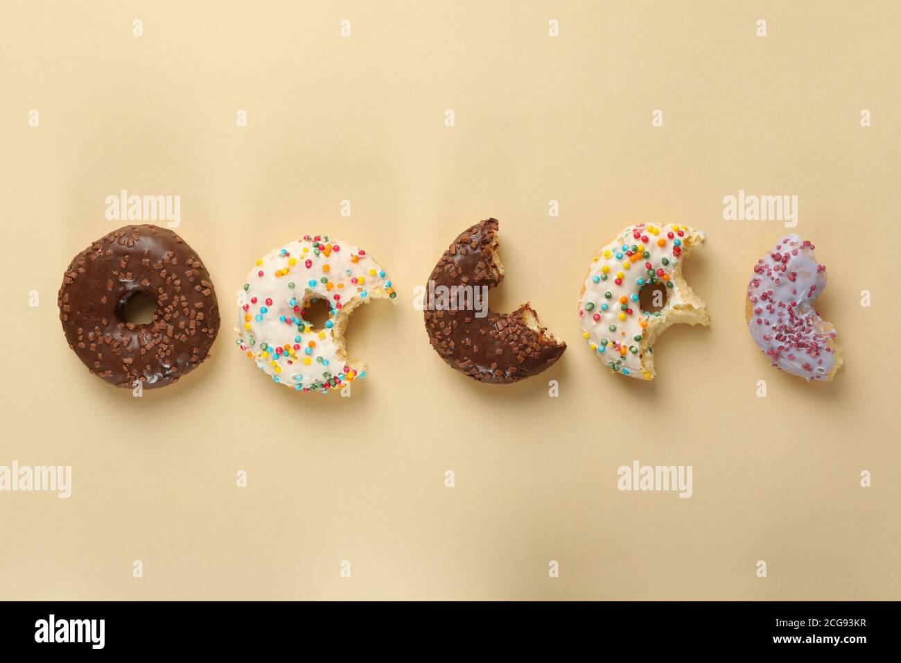 Tasty donuts on beige background, space for text Stock Photo