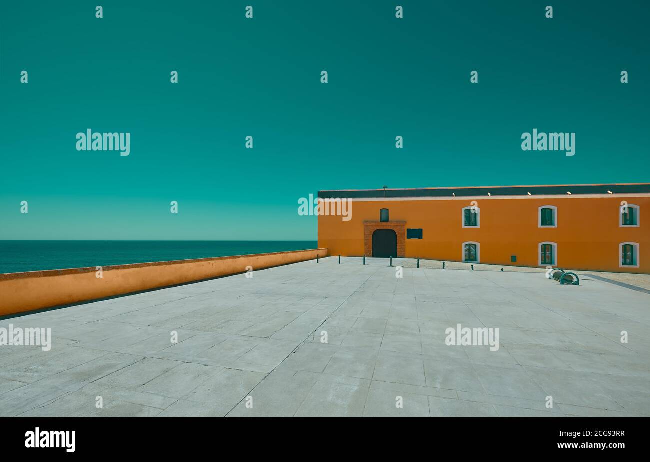 Empty esplanade with an orange building and sea in the background Stock Photo