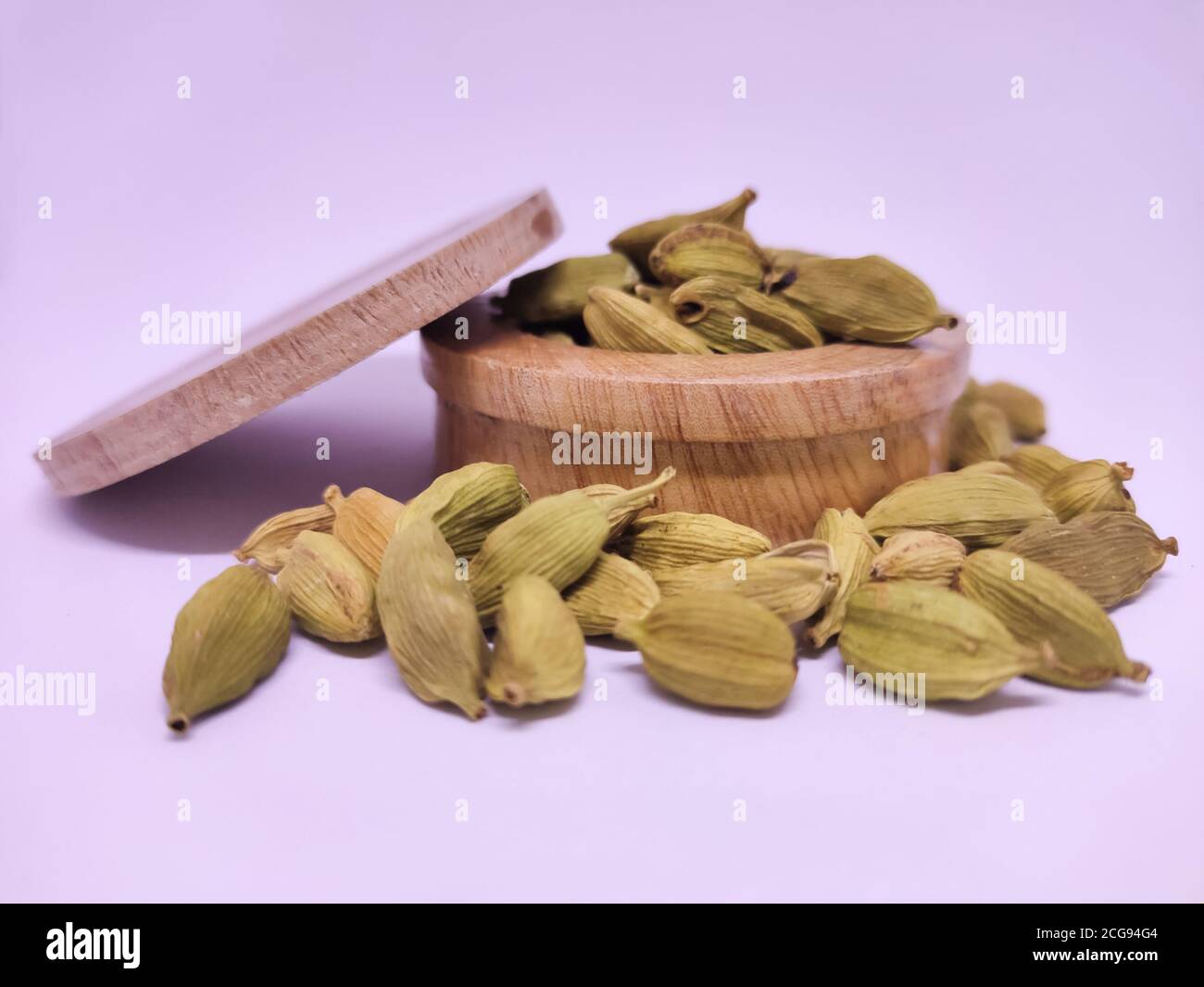 Whole cardamon seeds in traditional spice pot. White background Stock