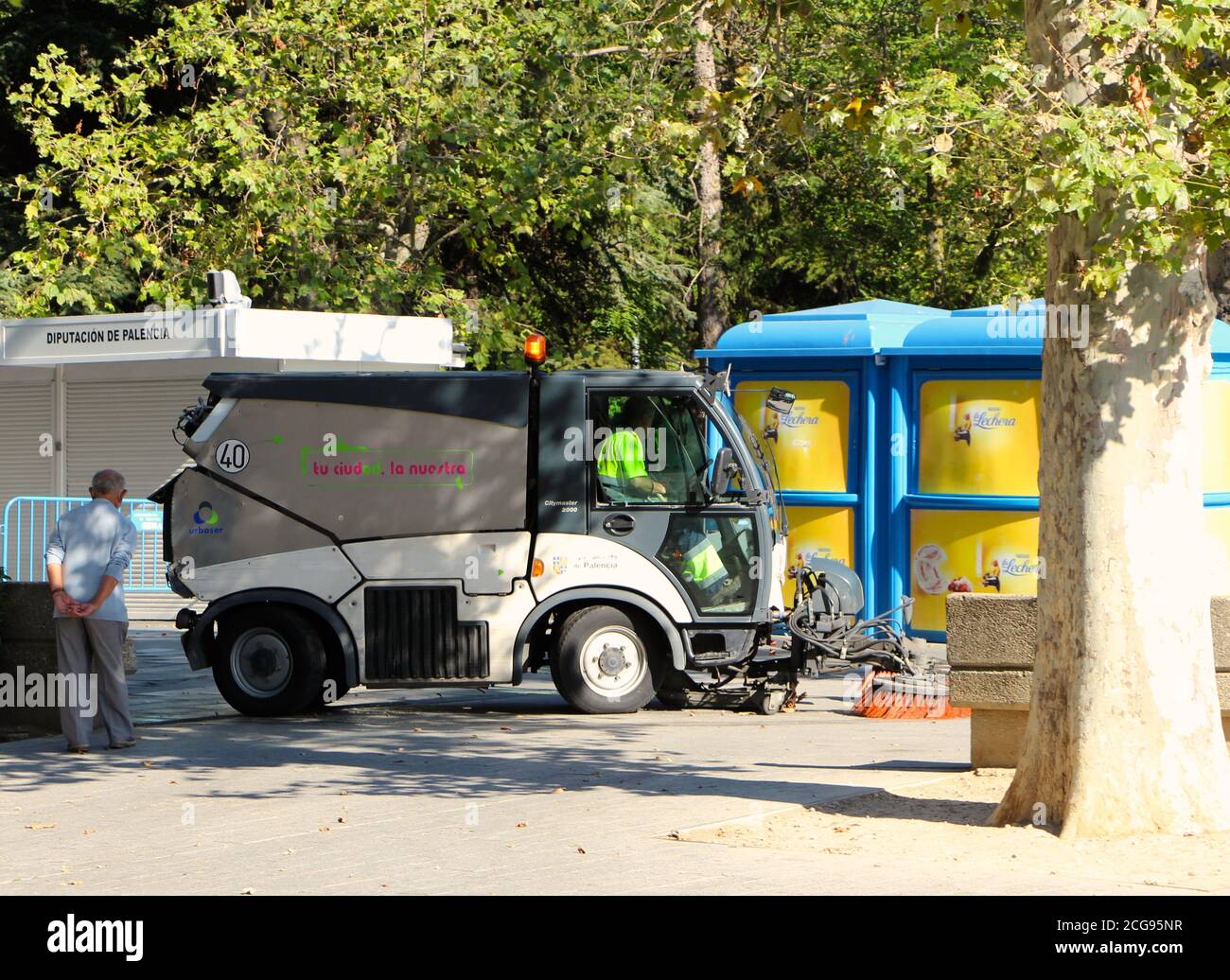 Hako Citymaster 2000 Euro 5 Footpath Street Sweeper in action in Palencia Castile and Leon Spain on a sunny summer afternoon Elderly man looking on Stock Photo