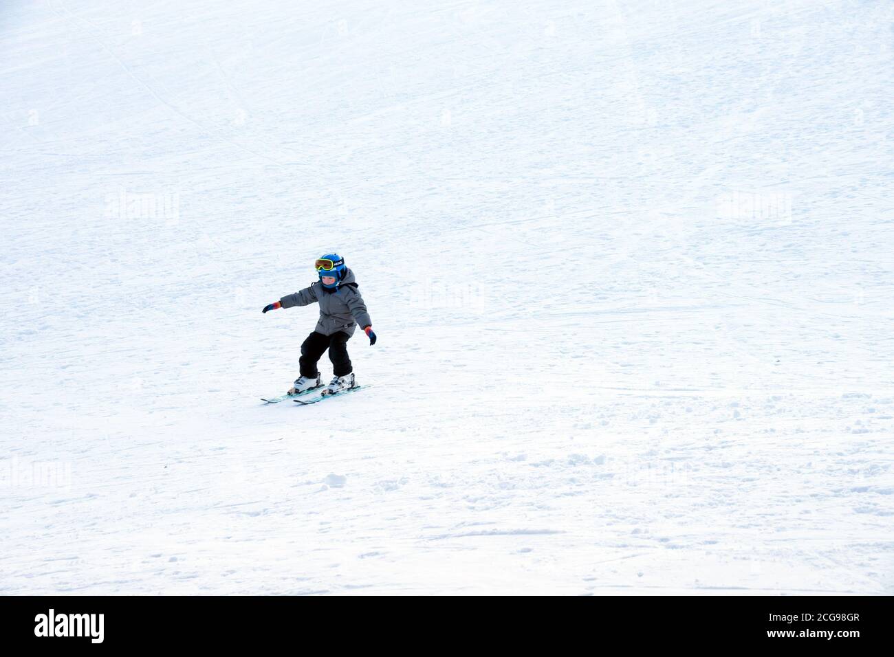 The boy goes downhill on a downhill skis from a mountain slope Stock ...