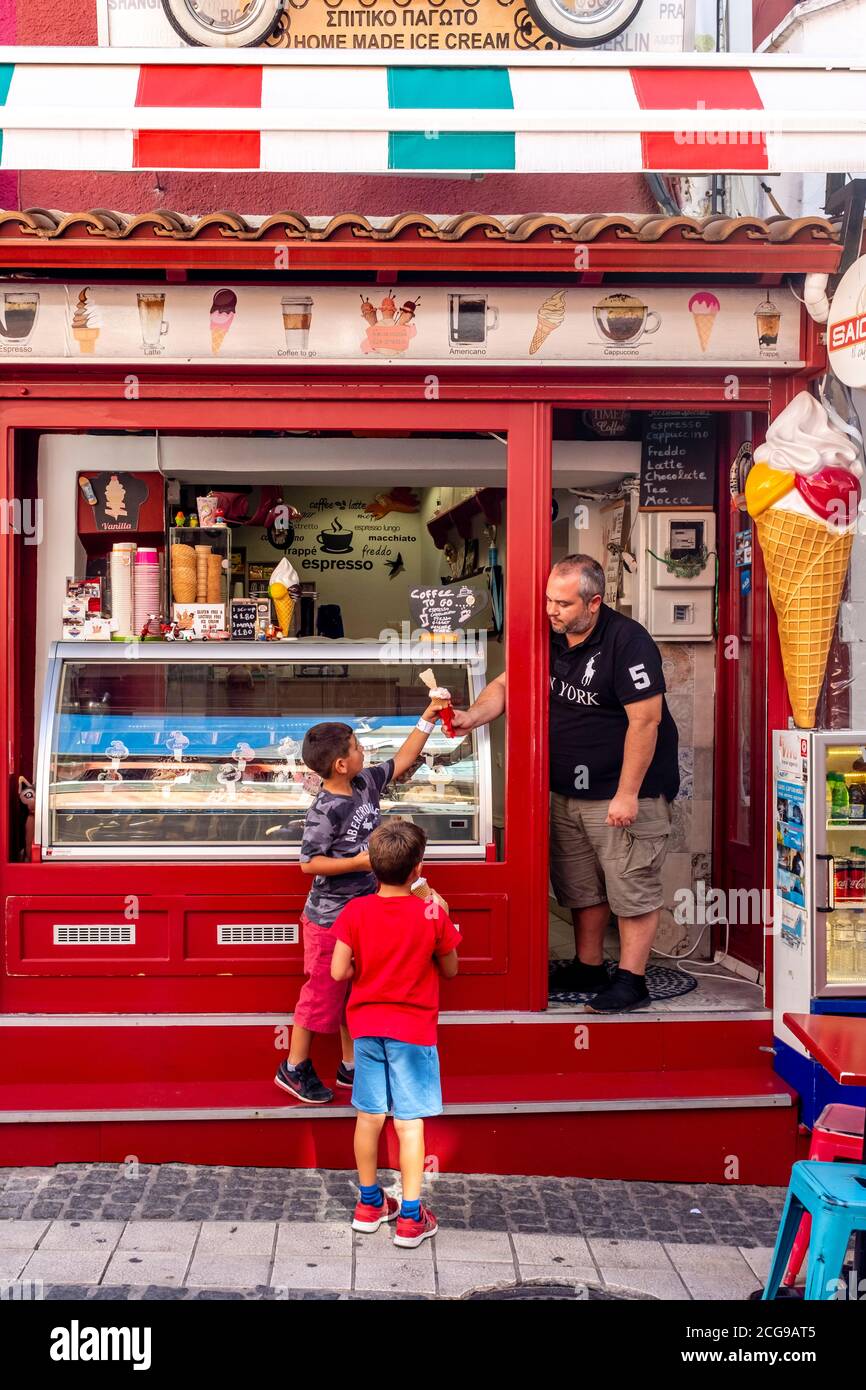 Two Local Boys Buying Ice Cream From A Shop In The Town Of Parga, Preveza Region Greece. Stock Photo