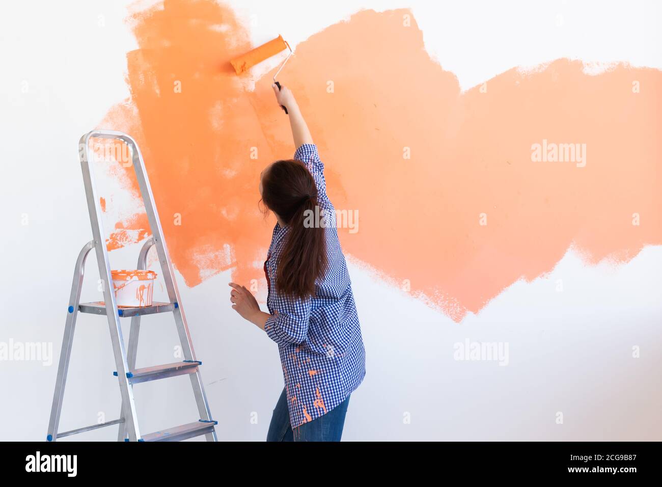 Dancing funny woman painting interior wall of new house. Redecoration,  renovation, apartment repair and refreshment concept Stock Photo - Alamy