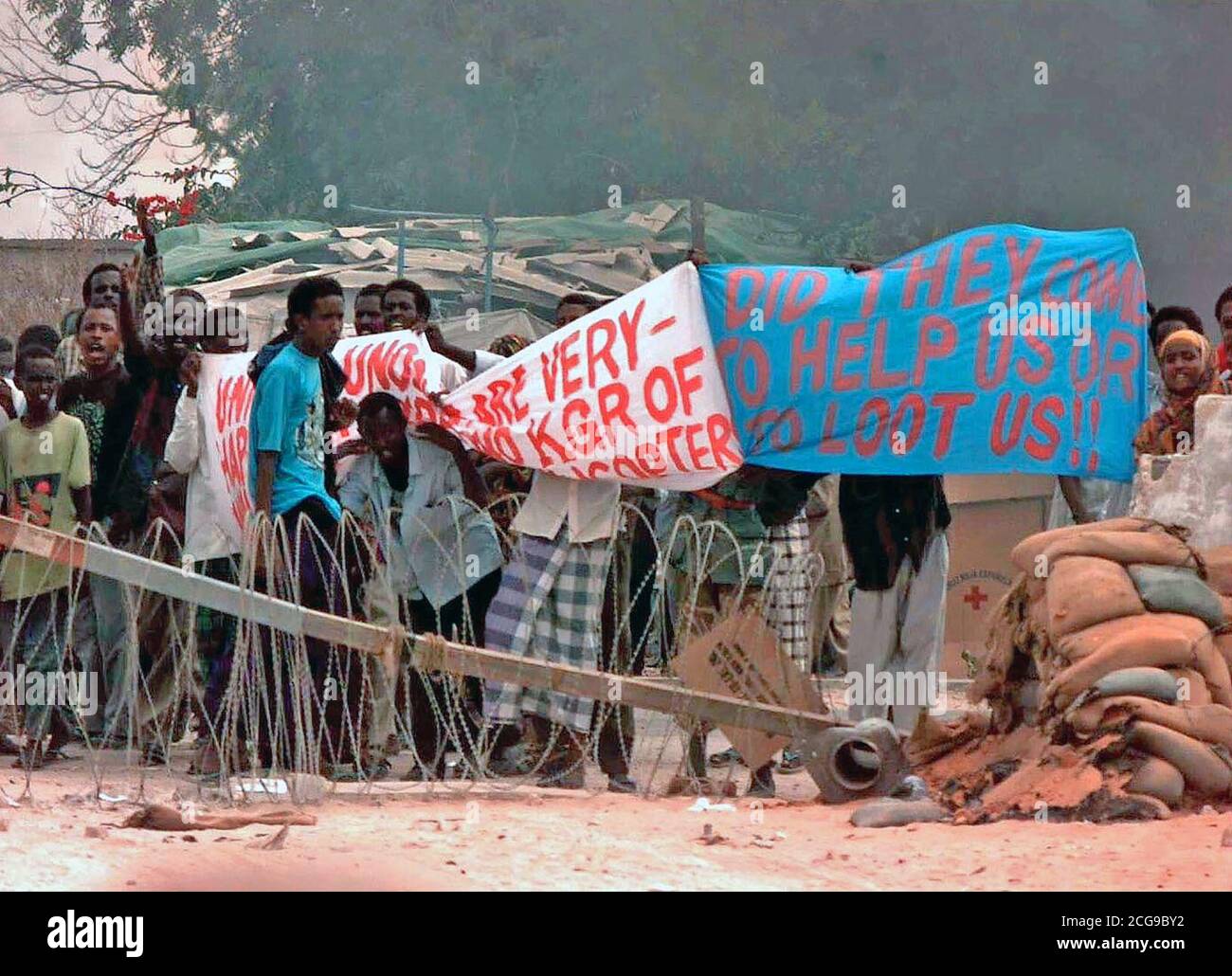 1993 - Somali people hold up a banner in protest at gate eight of the US Embassy in Mogadishu.  They seem to be protesting the existence of coalition forces assigned to Operation Restore Hope. Stock Photo