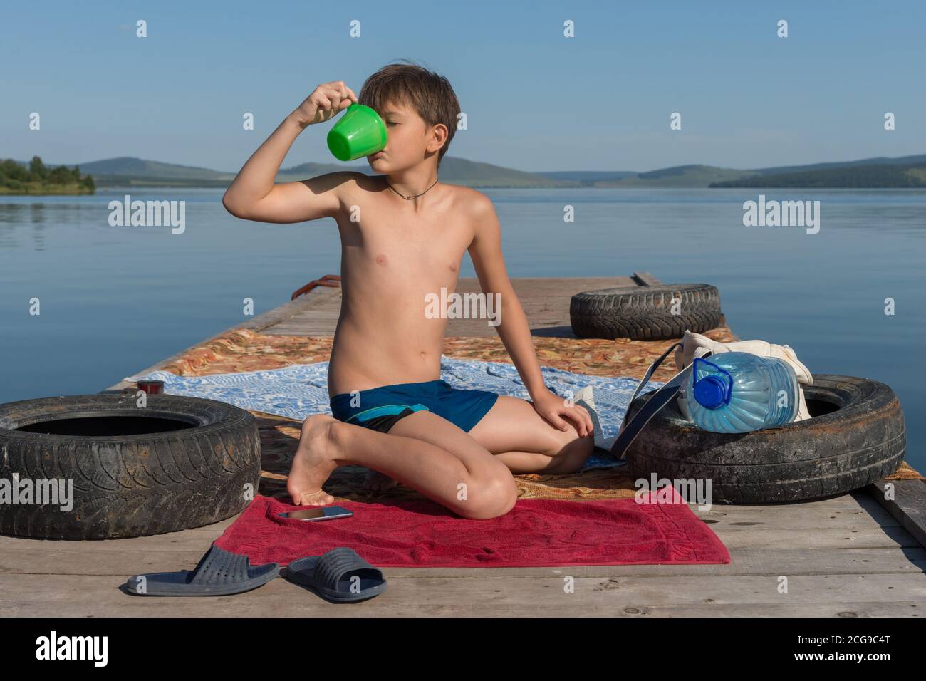 Мальчик подросток на пляже сидит