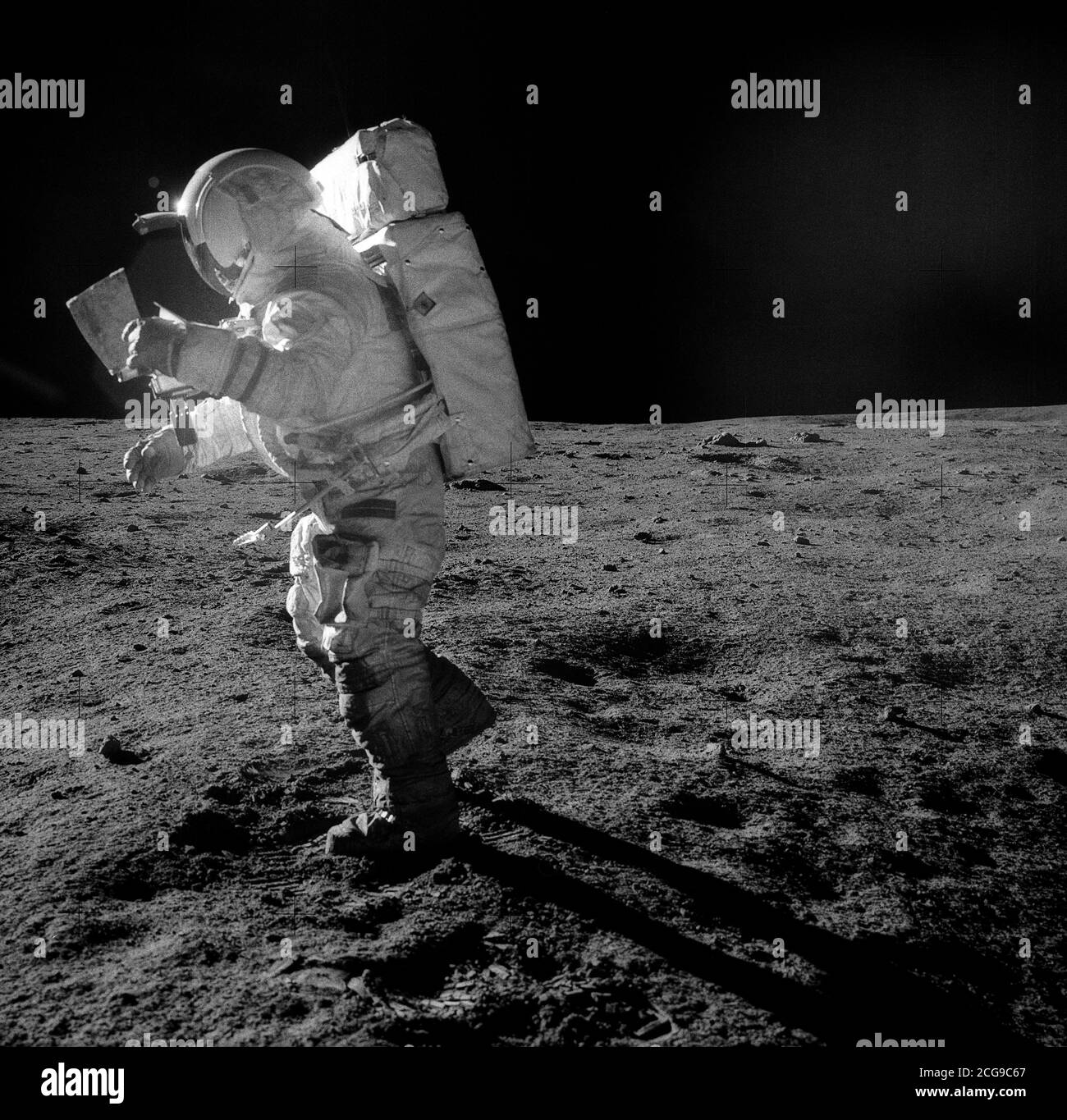(5-6 Feb. 1971) --- Astronaut Edgar D. Mitchell, lunar module pilot, moves across the lunar surface as he looks over a traverse map during an extravehicular activity (EVA). Stock Photo