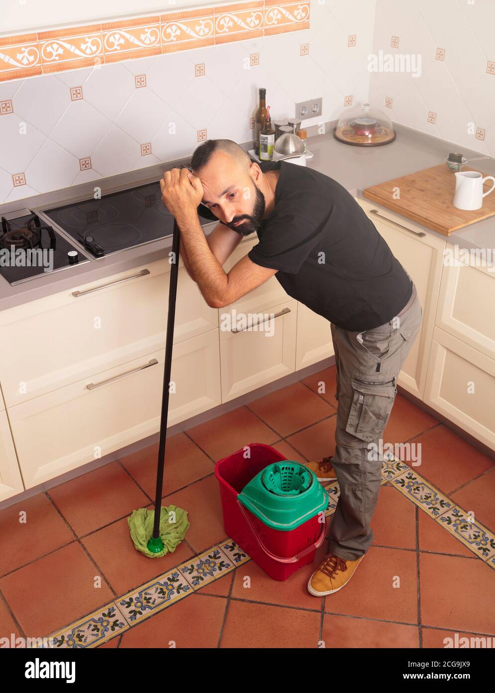 High angle view of a tired young hispanic man mopping the floor Stock Photo