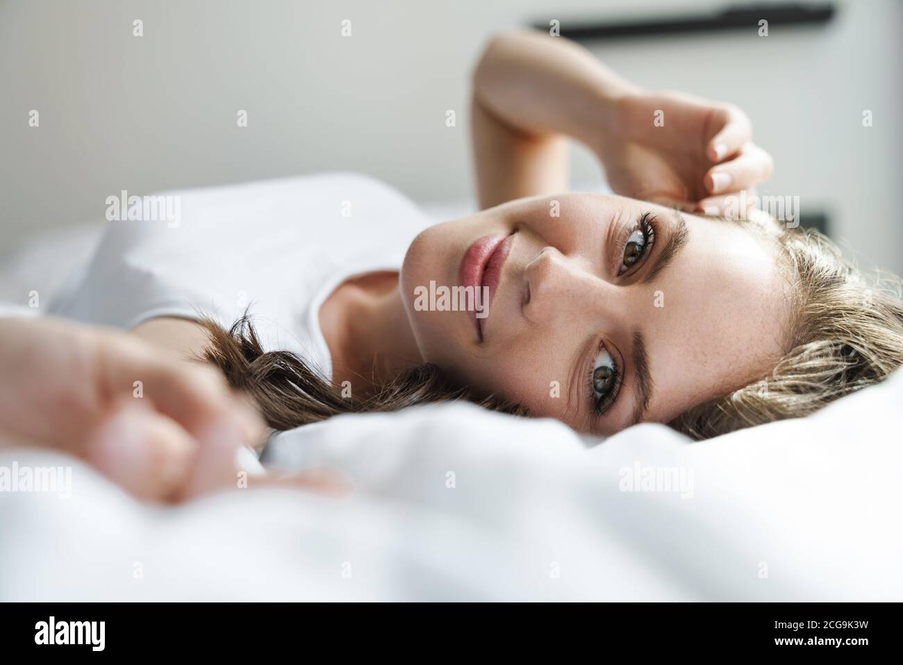 Image of beautiful happy woman smiling and looking at camera while ...