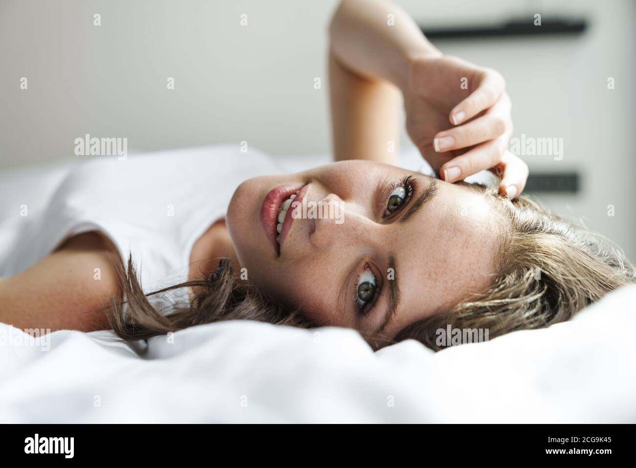 Image of beautiful happy woman smiling and looking at camera while ...