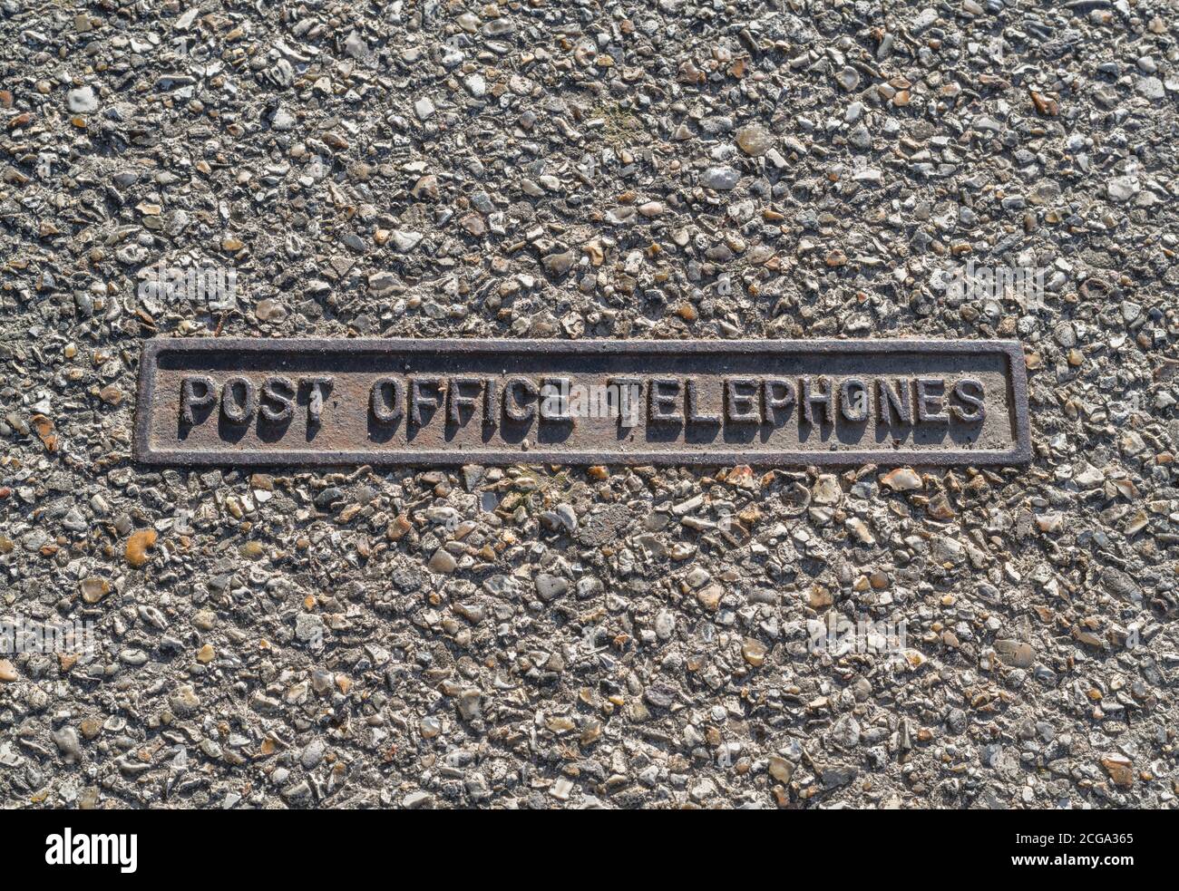 Pathway telephone line inspection cover from the old days when the Post Office Telephones had a monopoly on communications technology. Stock Photo