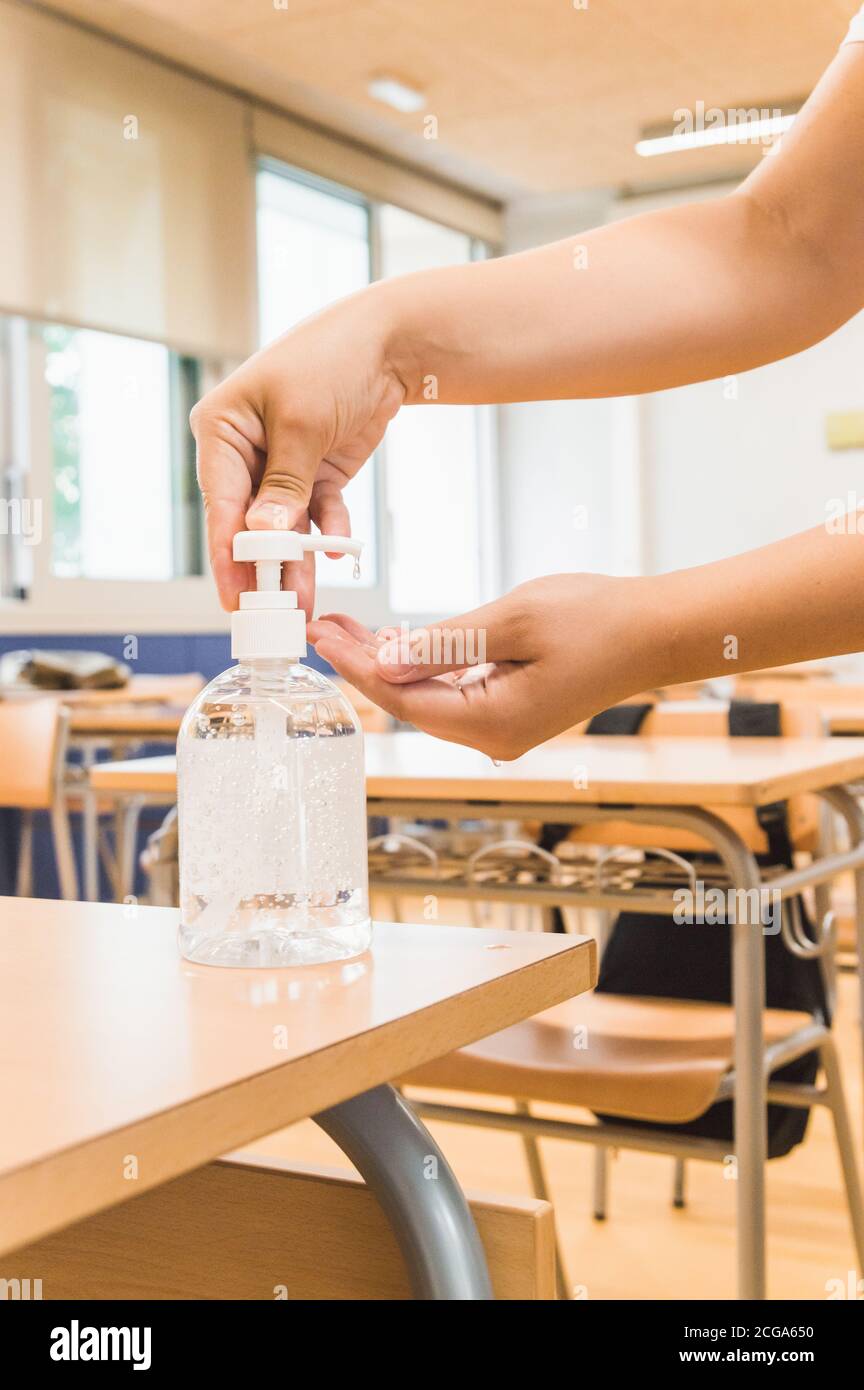 unrecognizable student using antibacterial gel in the classroom Stock Photo