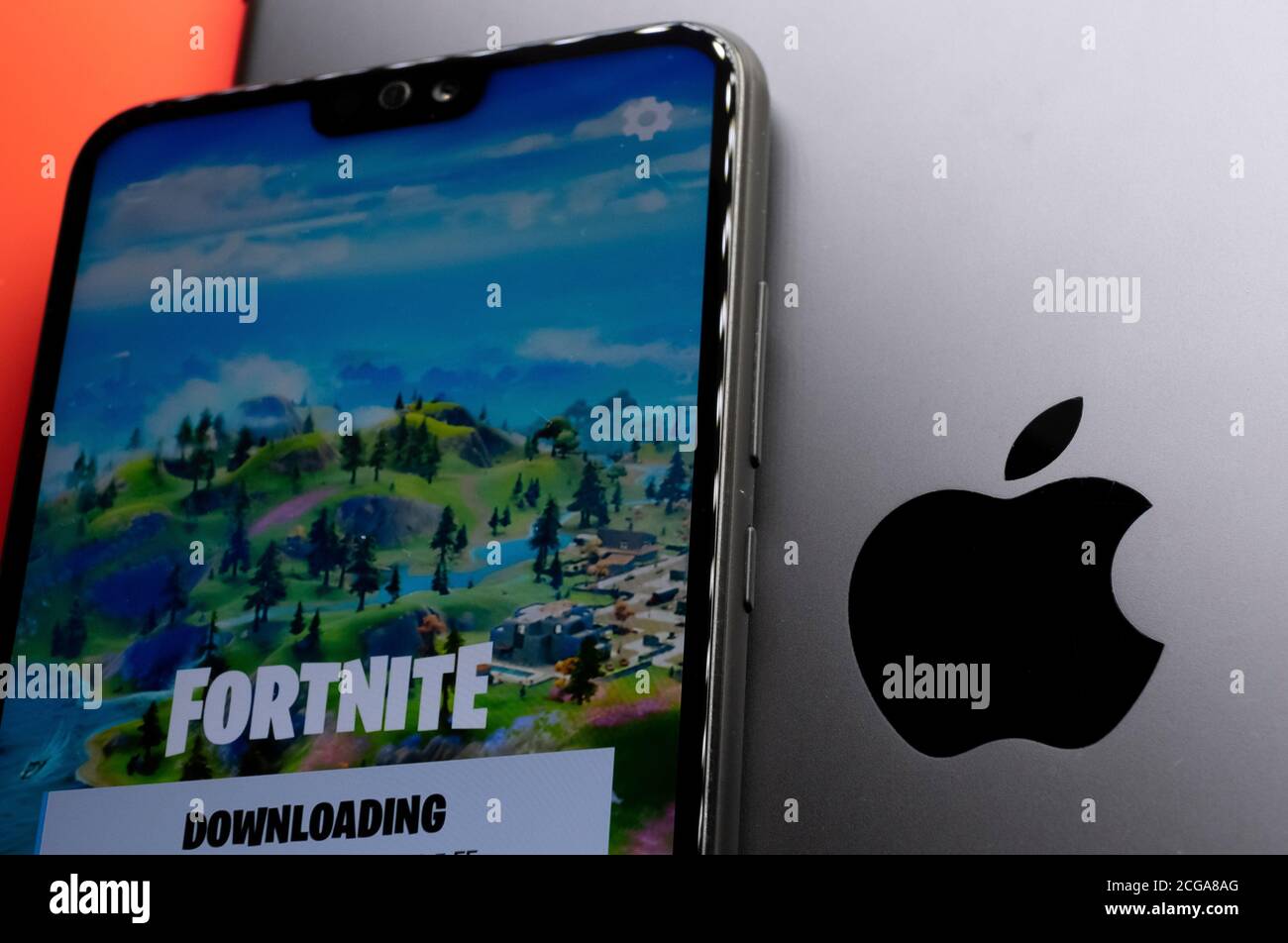 Stone / UK - September 9 2020:  Apple logo seen on  ipad and smartphone with Fortnite game screen from Epic Games placed on top. Epic Games vs Apple Stock Photo