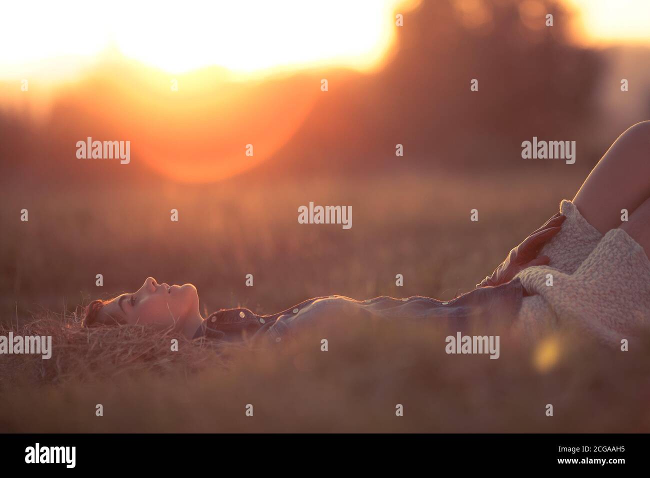 Young woman lays down in the countryside for a relaxing moment Stock Photo