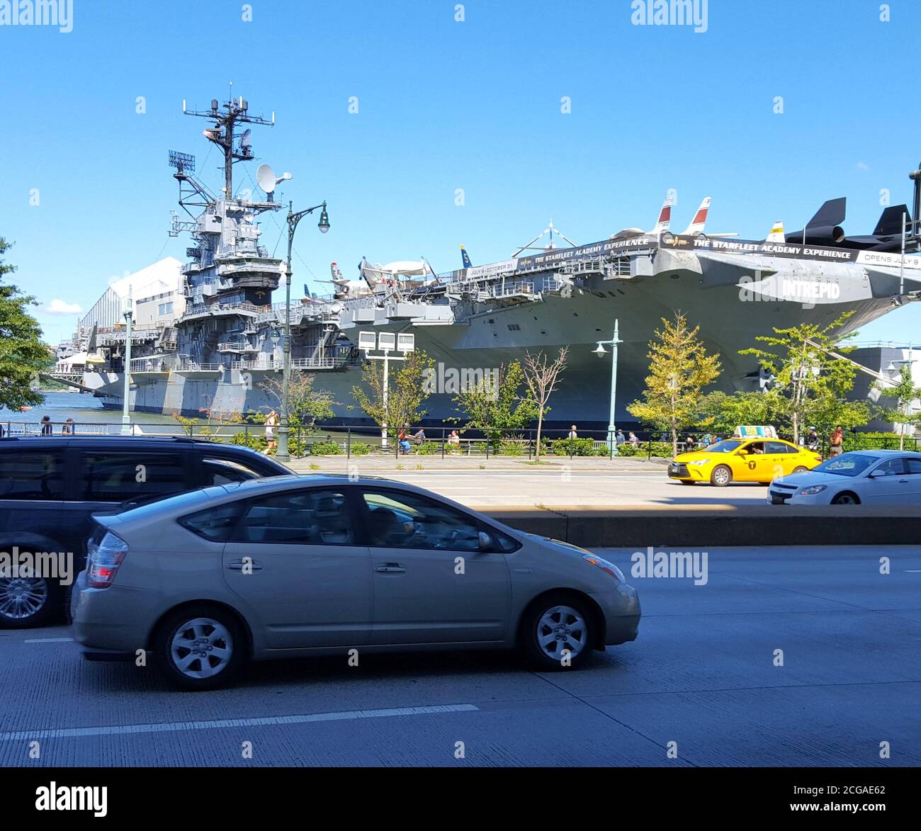Cars driving by the Intrepid Sea, Air & Space Museum, New York City, United States Stock Photo