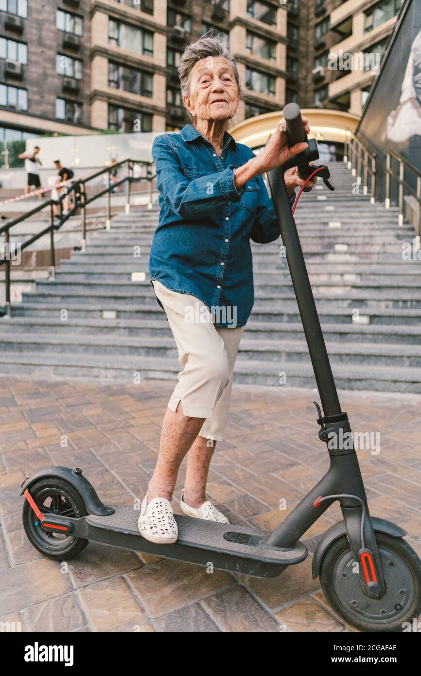 Active old woman riding electric scooter. Retired lady uses environmentally  friendly city vehicle. Granny very old with gray hair, active and Stock  Photo - Alamy