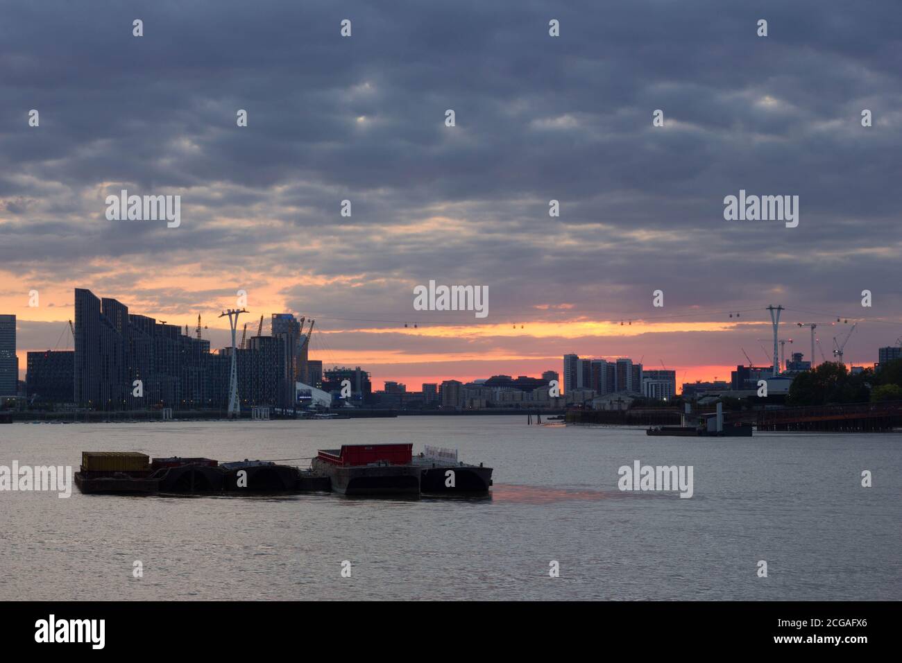 Thick and dark sunset Clouds over Canary Wharf skyline, River thames ...