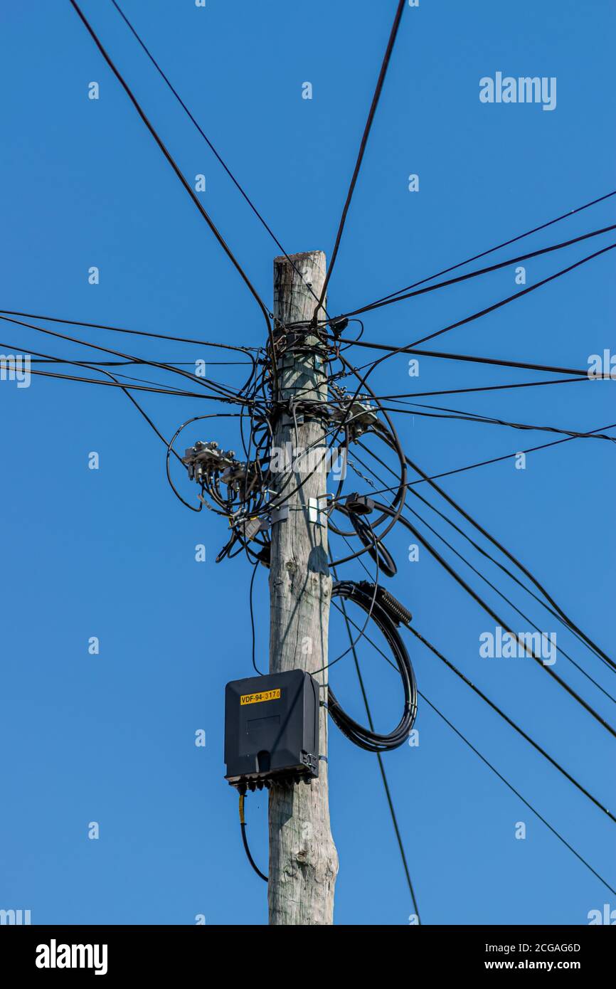 Cables for internet and tv distribution by Vodafone company in Portugal. Internet and tv cables hanging outside habitations, visual pollution. Stock Photo