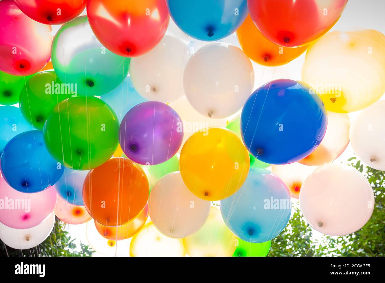 Sunlight against colorful gasfilled balloons attached to the yarn