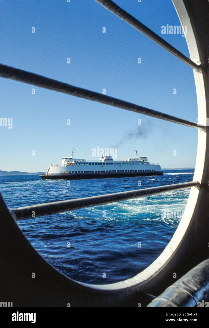 Washington State Ferry on Puget Sound viewed through porthole of another ferry boat, Seattle, Washington USA Stock Photo