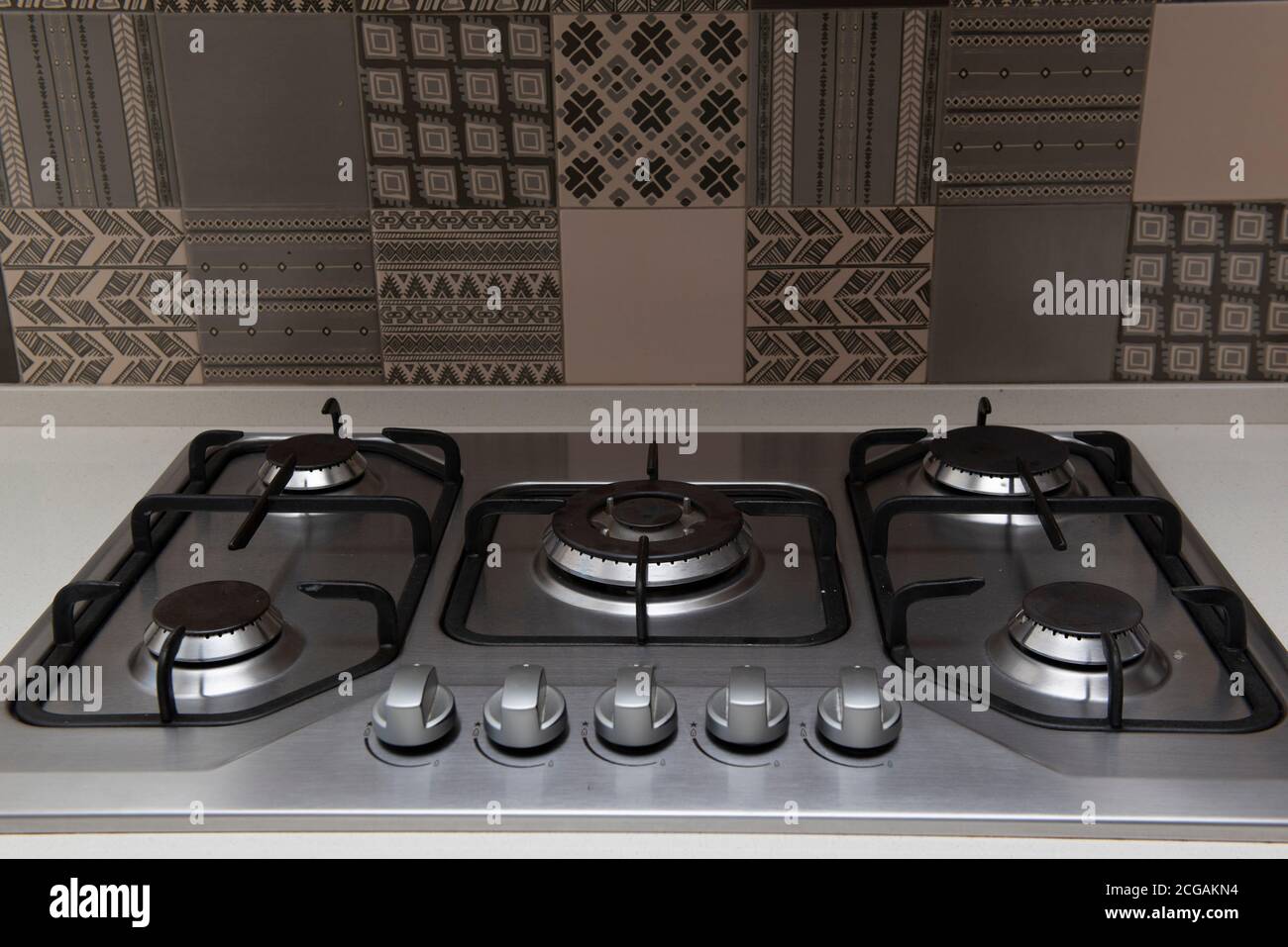 A closeup shot of the stovetop of a modern stove. Stainless steel stove