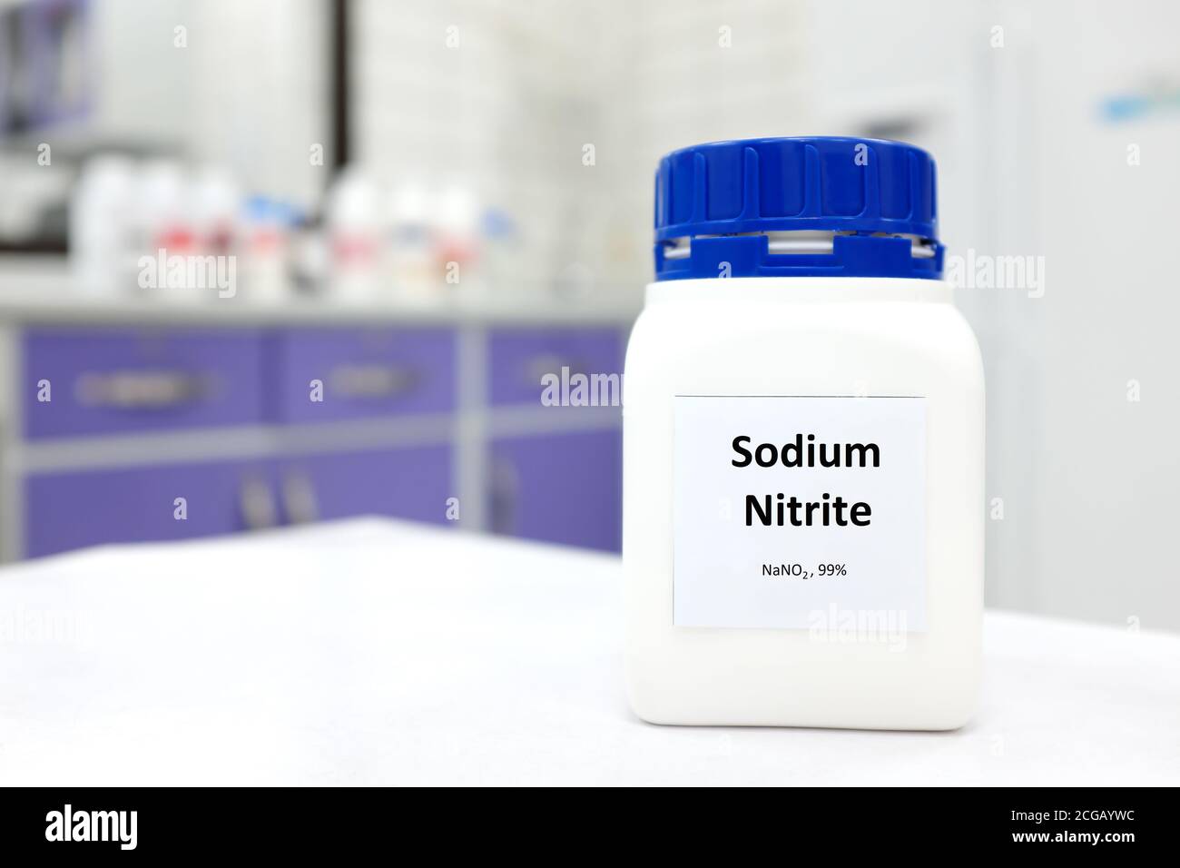 Selective focus of a bottle of sodium nitrite preservative chemical compound. White laboratory background with copy space. Stock Photo
