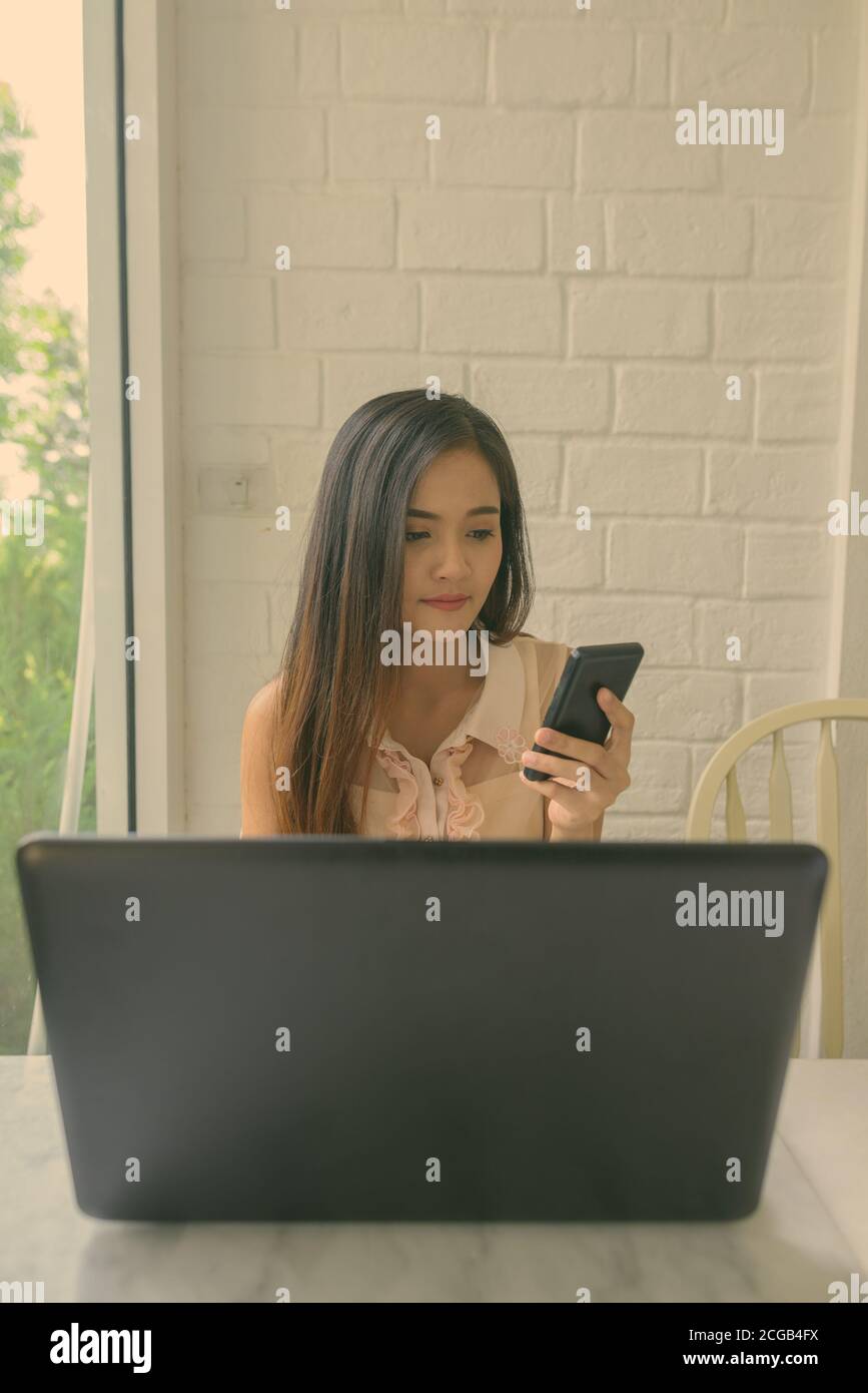 Young beautiful Asian woman relaxing at the coffee shop Stock Photo - Alamy