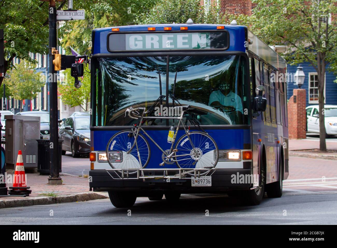Annapolis, MD, USA 08/25/2020: A blue bus is making a left turn at the traffic lights in downtown Annapolis. The  driver is wearing a face mask. It is Stock Photo