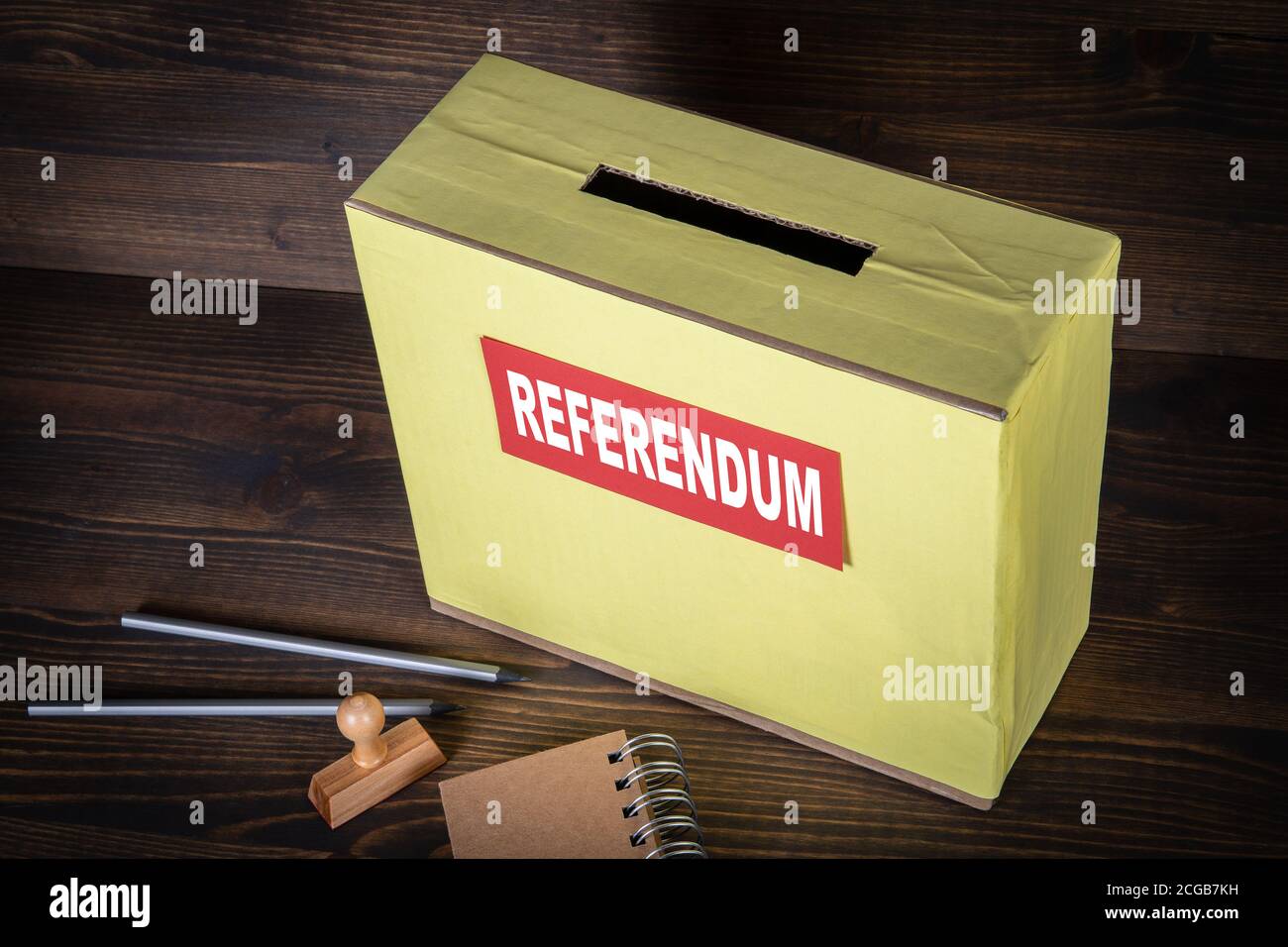 REFERENDUM. Ballot box on a wooden background. Pencils, stamp and notepad Stock Photo