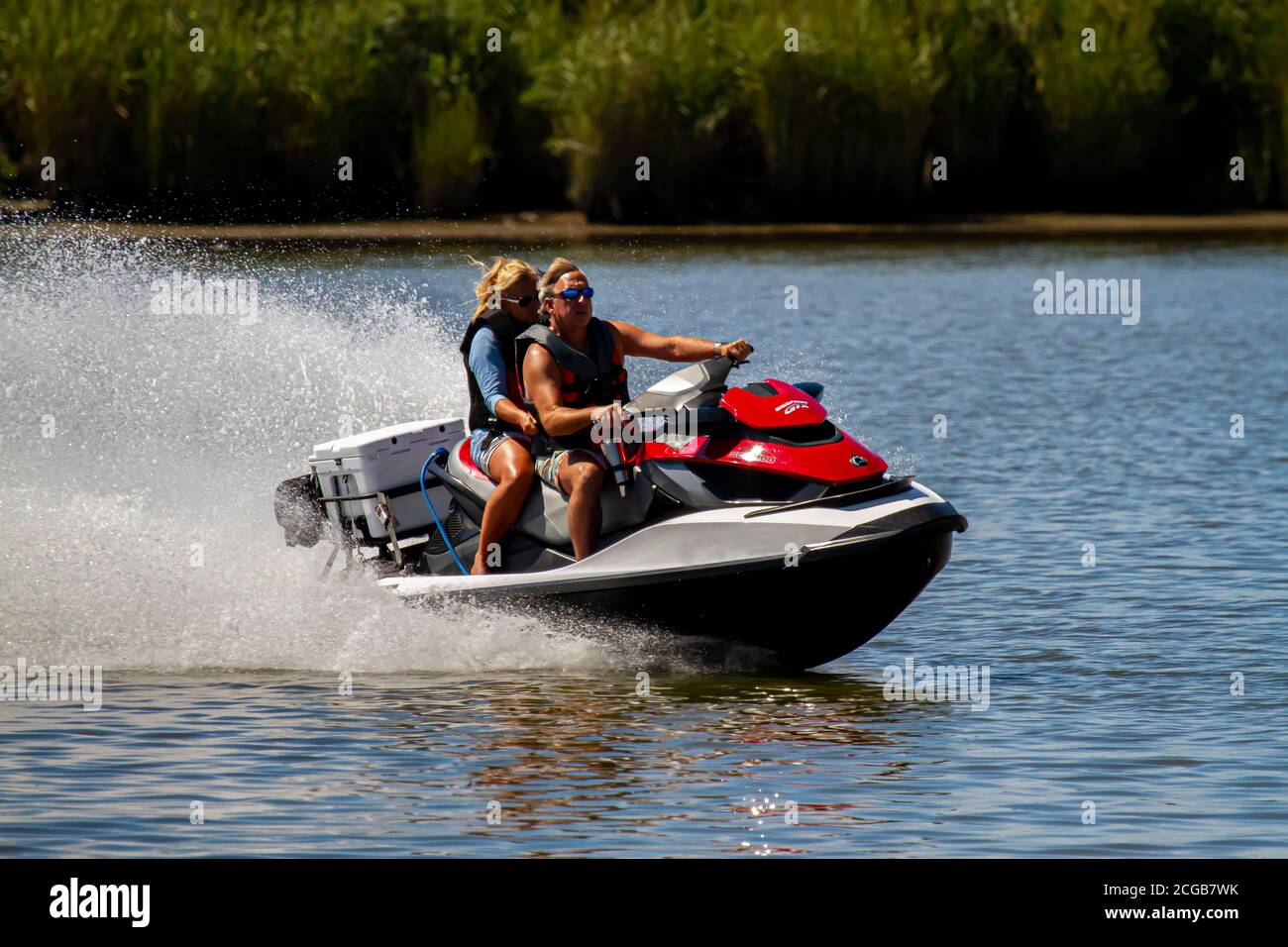 Eastern Neck Island, MD, USA 08/30/2020: A middle aged caucasian couple wearing life vests are on a Sea Doo GTX personal water craft. They move really Stock Photo