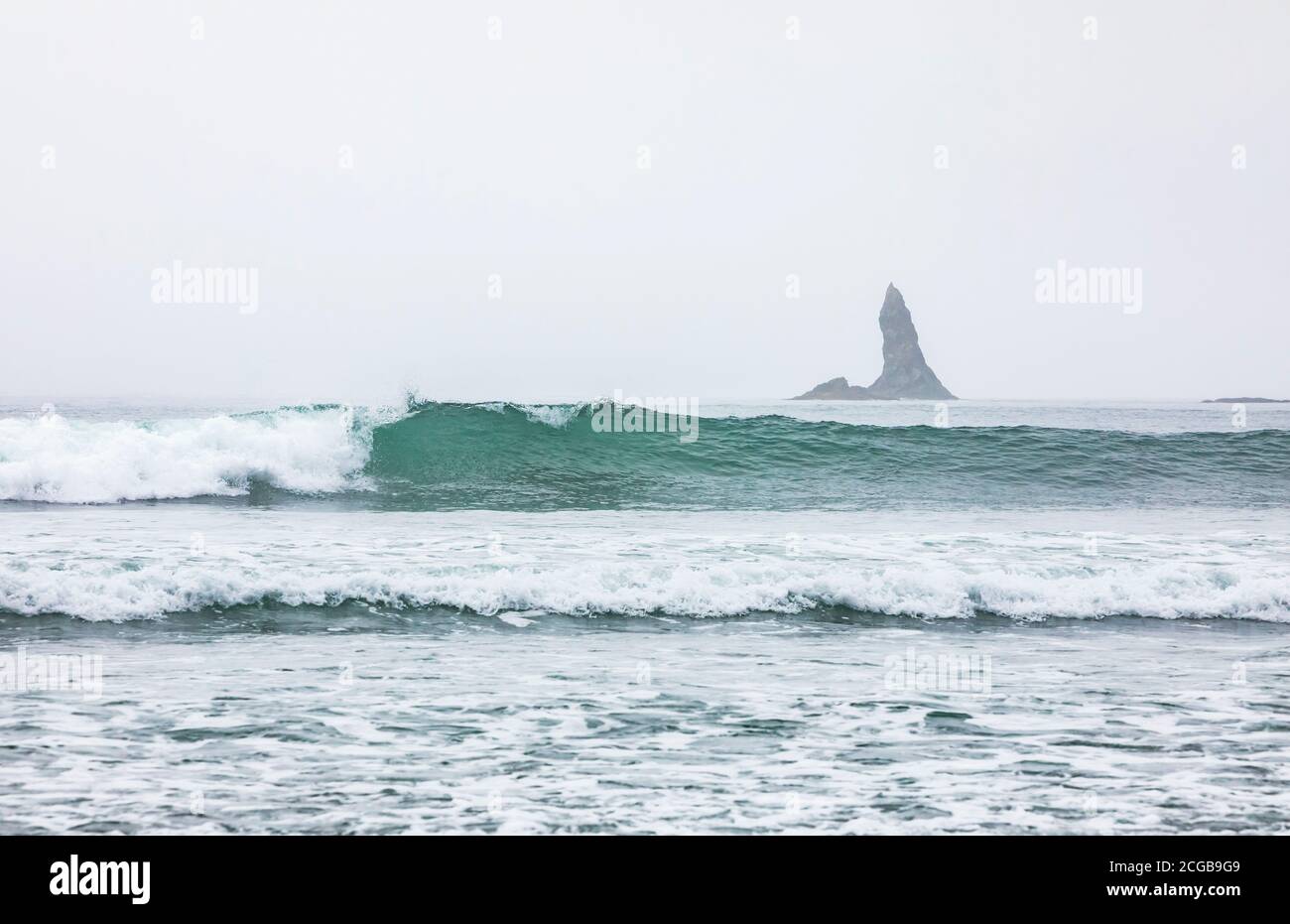 A breaking wave and a pointy offshore rock spire, 2nd Beach, Olympic National Park Coastal Preserve. Stock Photo