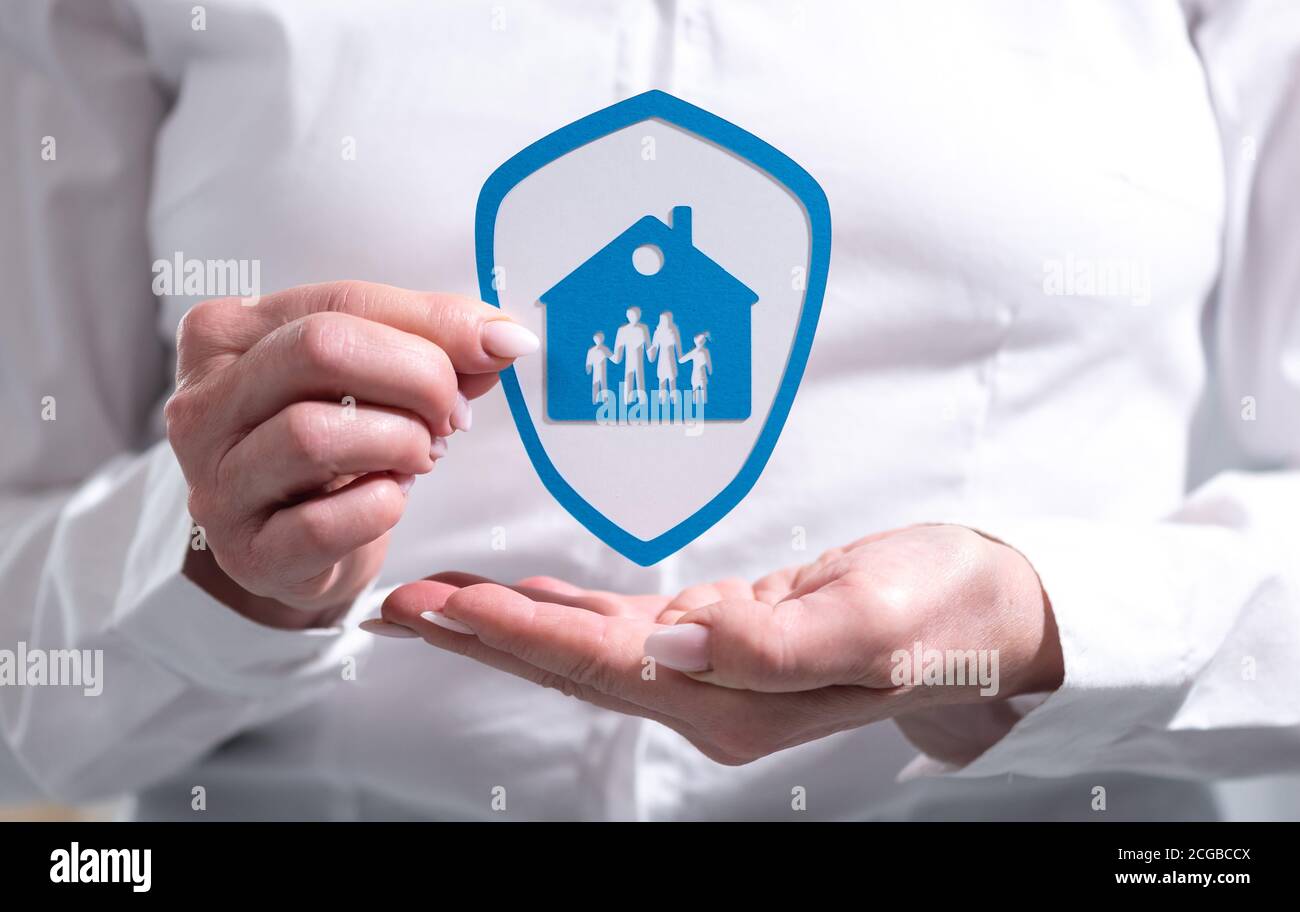 Insurance Protection Hand Concept of family and house insurance with paper shield held by female ...