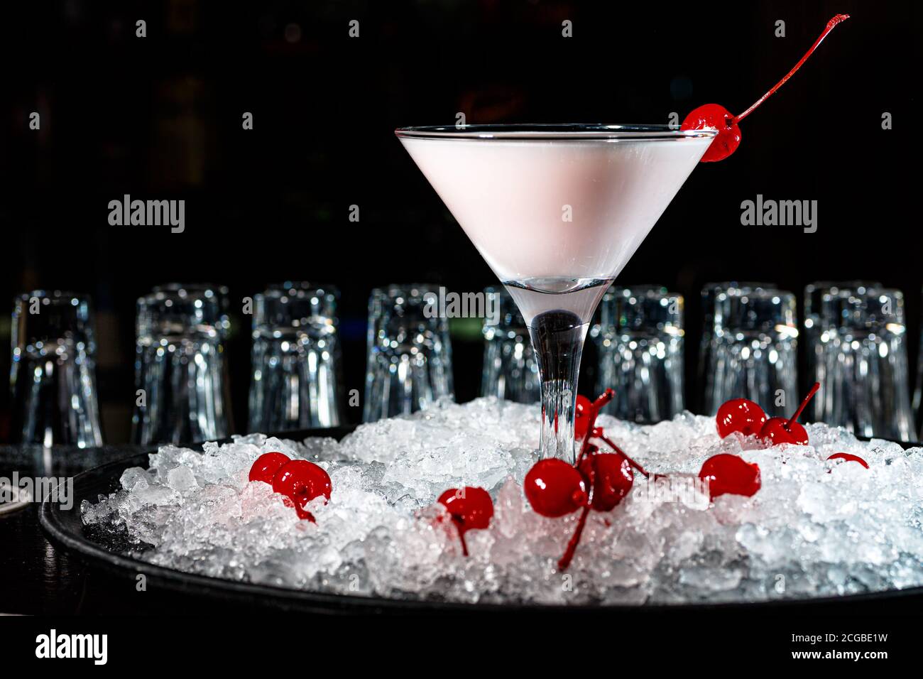 The bartender prepares a cocktail with yogur or milk on the counter of the dark bar. Stock Photo