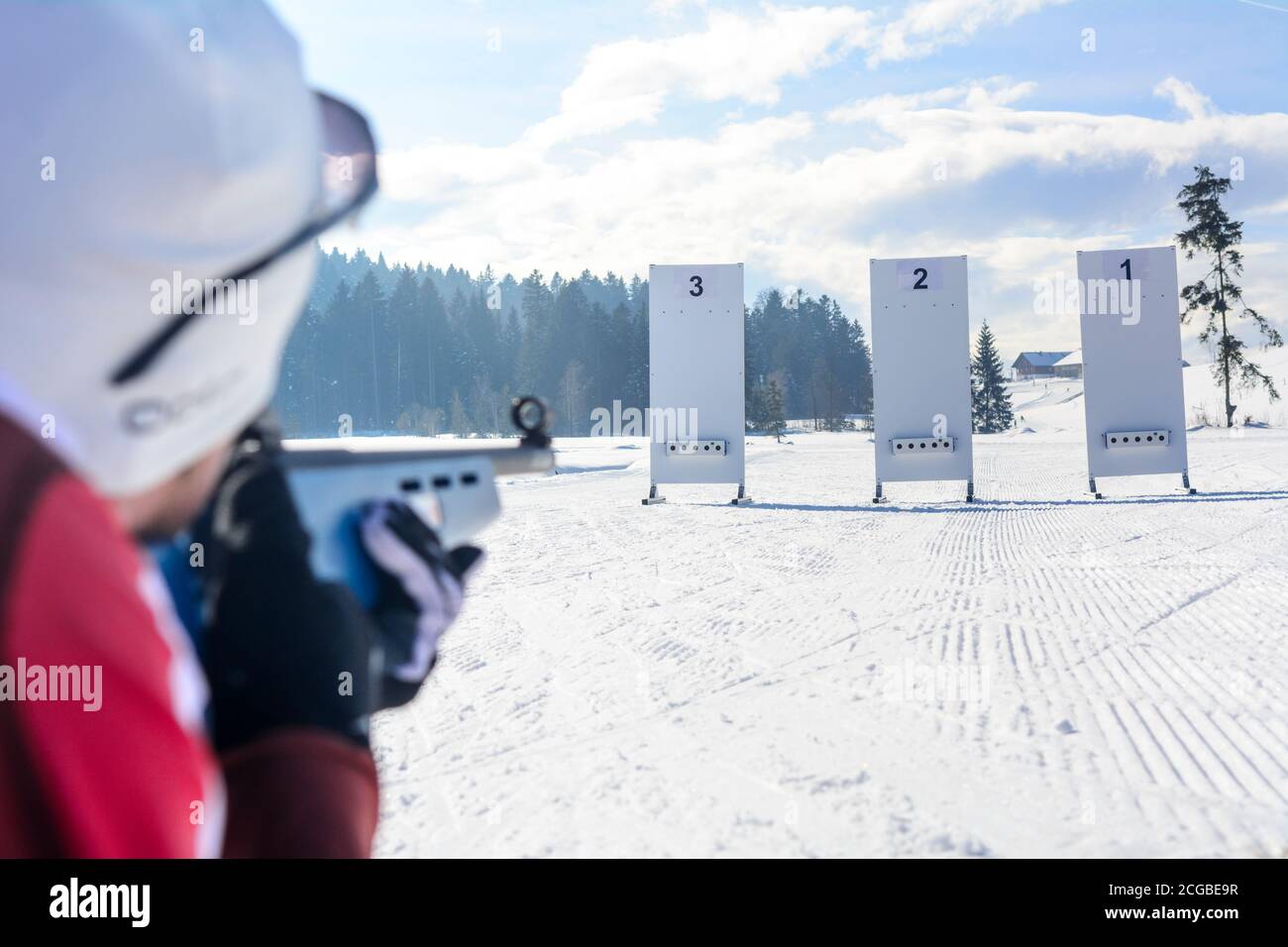 Leisure biathletes shooting with a laser rifle on a cold and sunny winter day Stock Photo