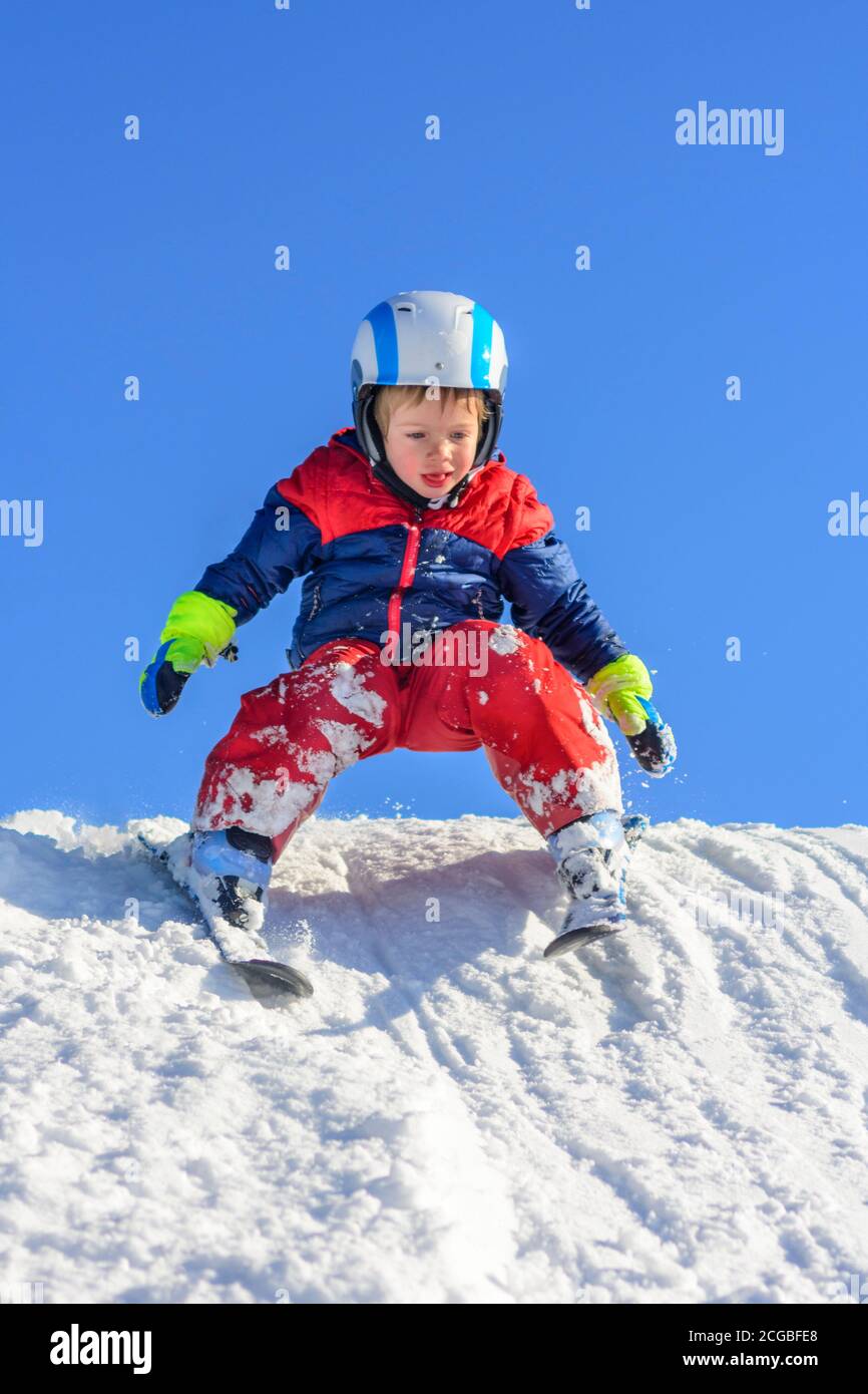 Little skiers learn to ski on a well-prepared slope and have a lot of fun. Stock Photo
