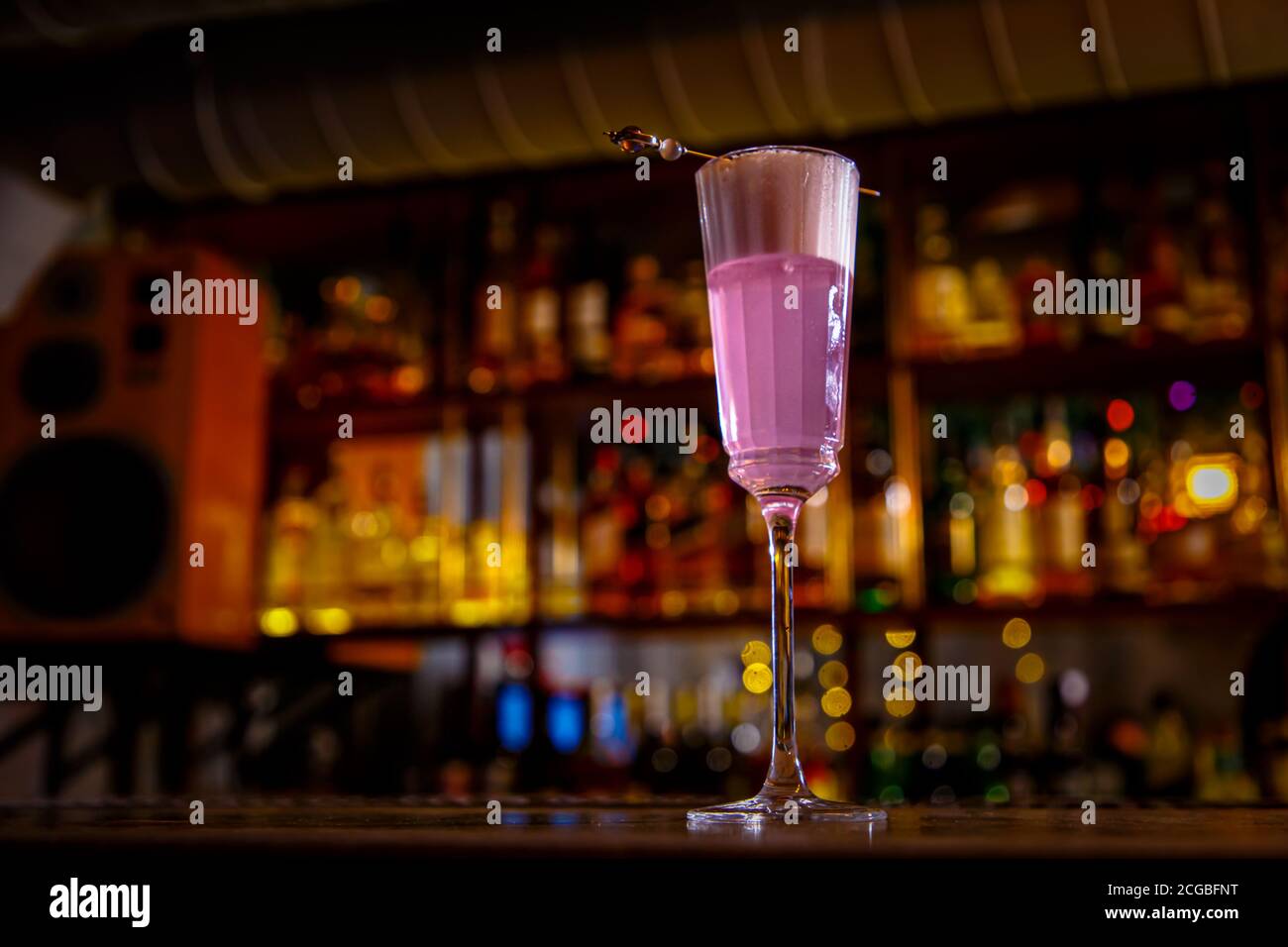 A purple Sauer cocktail in a tall glass with foam stands on the bar Stock Photo