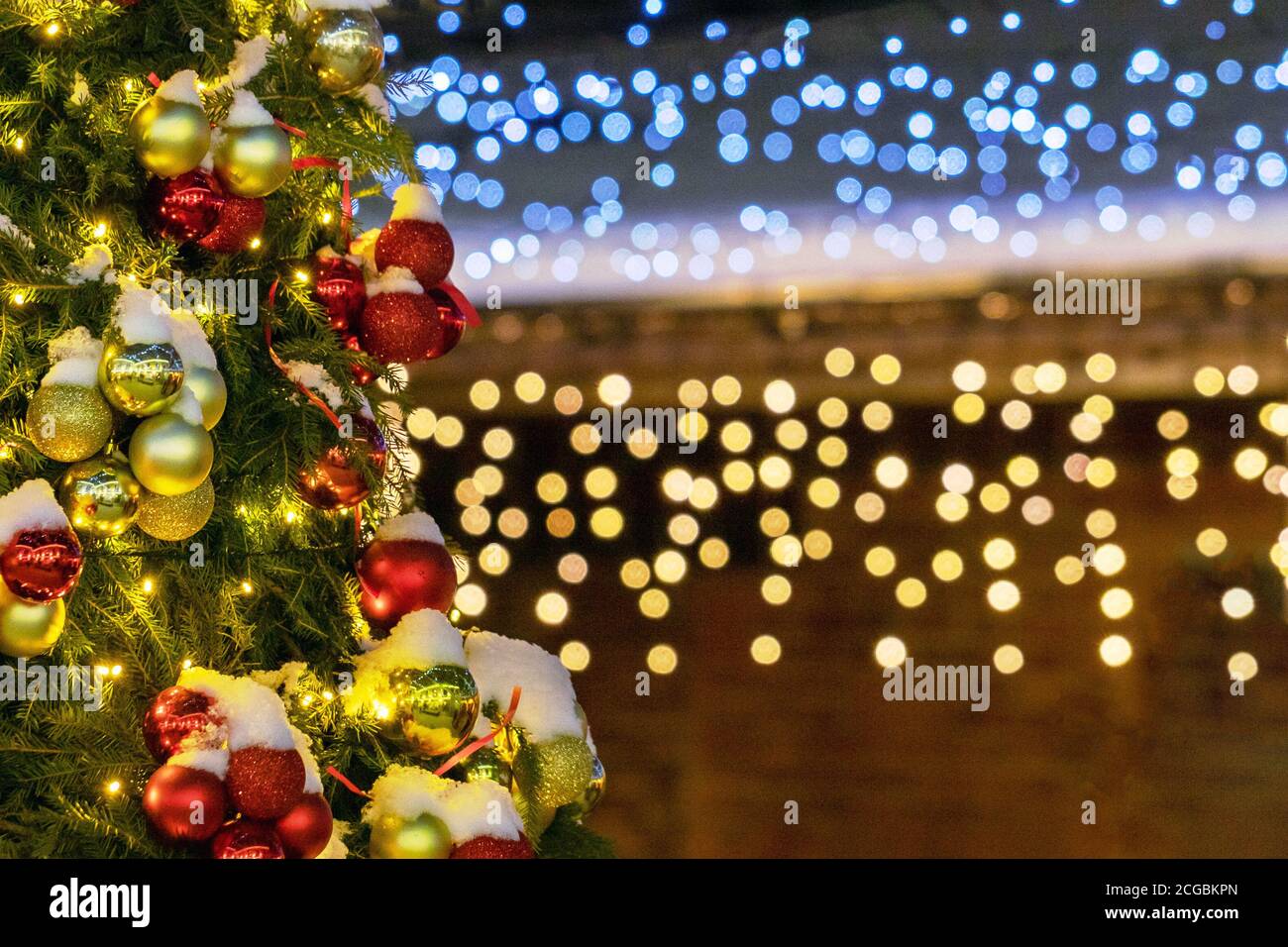 Decorated Christmas tree on blurry background with shiny lights bokeh Stock Photo
