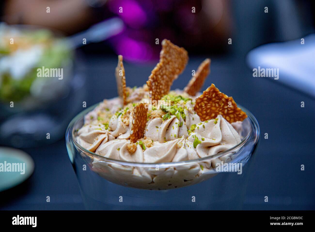 Dessert. Cream with sesame chips is in the glass. Stock Photo